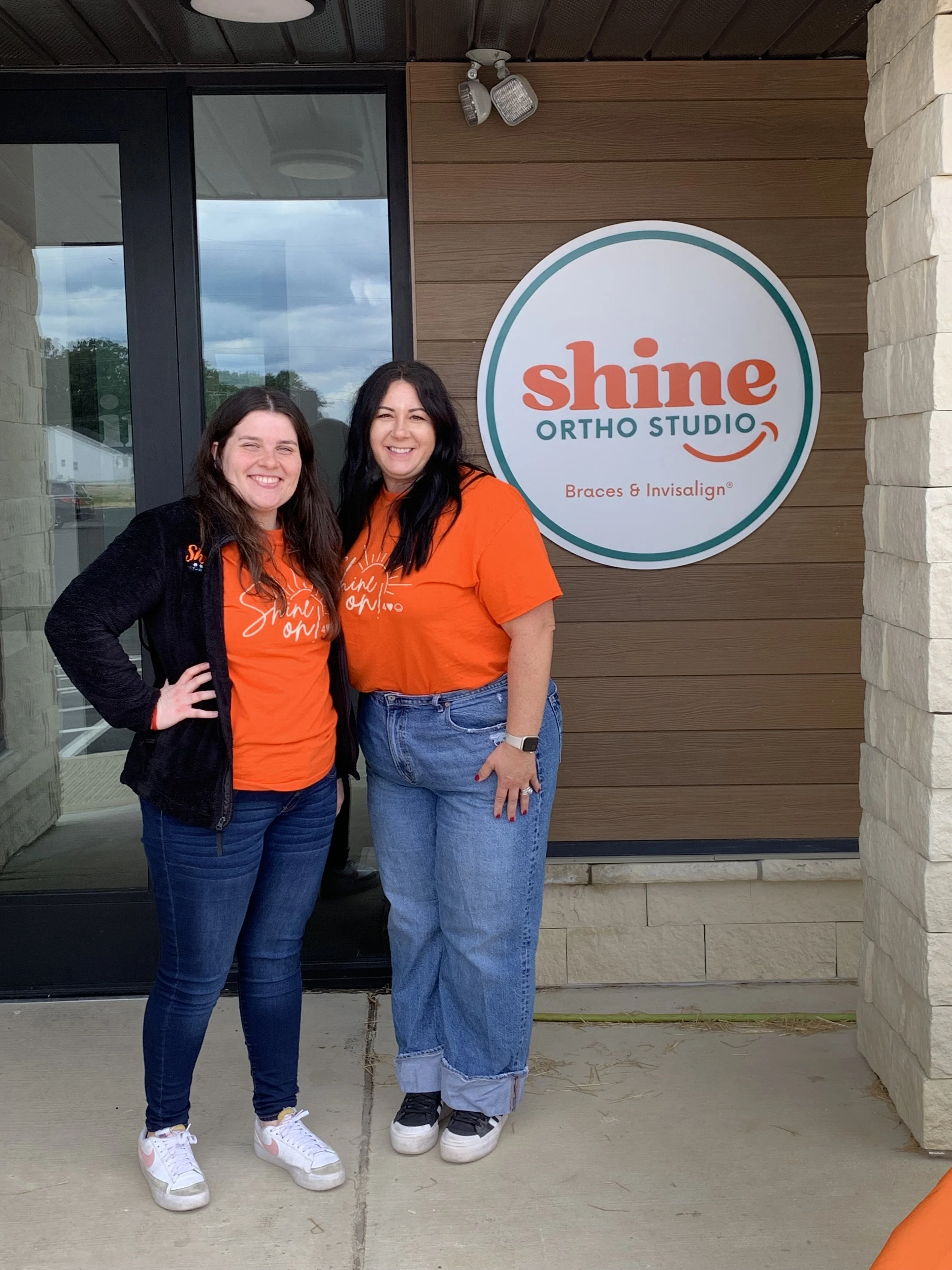 Shine Ortho Studio team members posing together in front of the office entrance during the open house event.