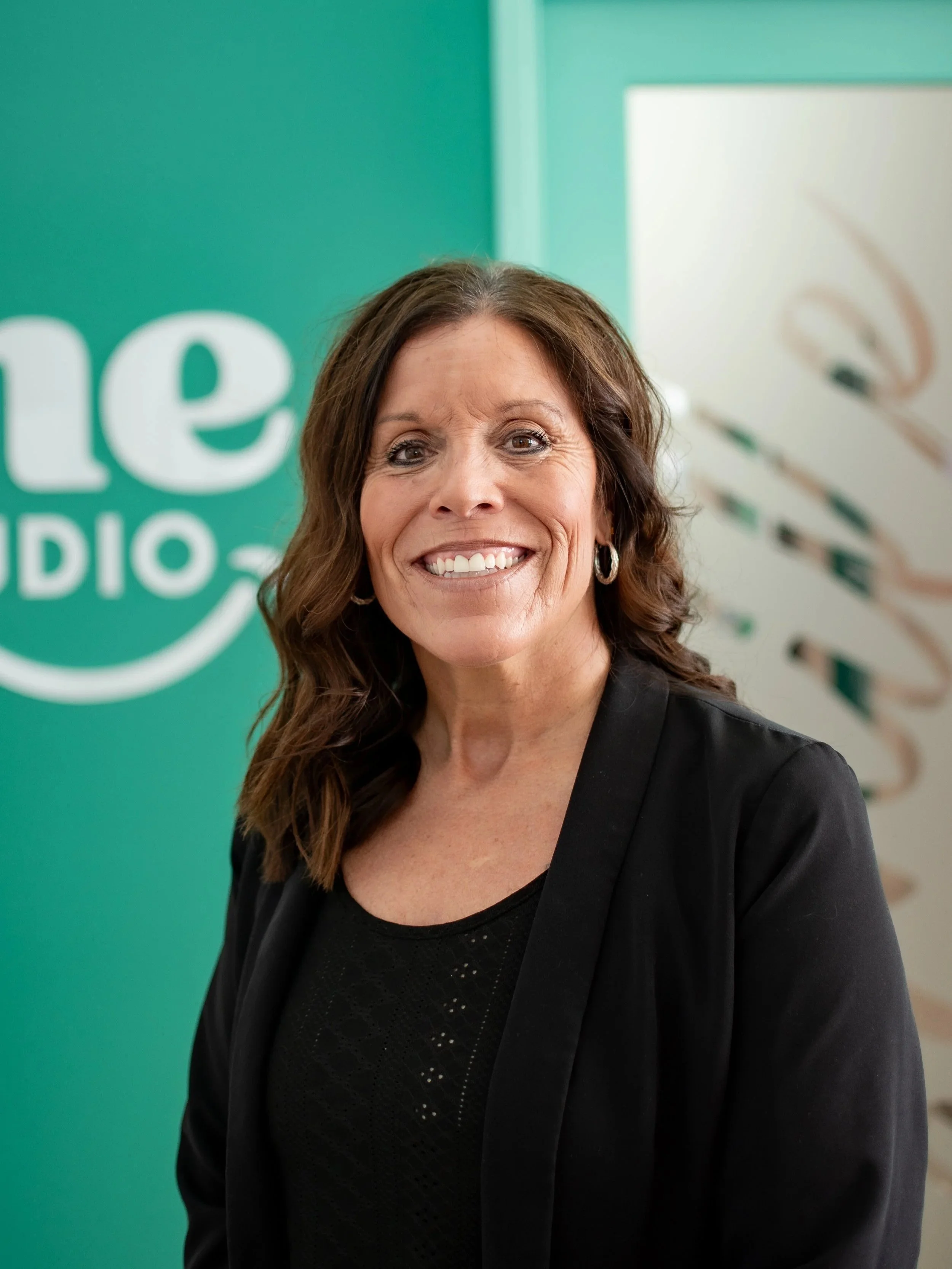 Jena Riseborough, financial and insurance coordinator at Shine Ortho Studio, smiling in the office