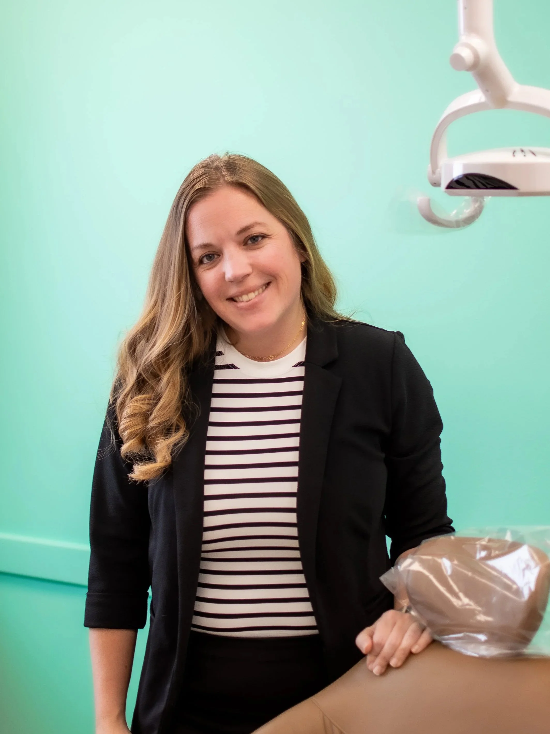 Renae Hendricks, treatment coordinator at Shine Ortho Studio, smiling in the orthodontic office