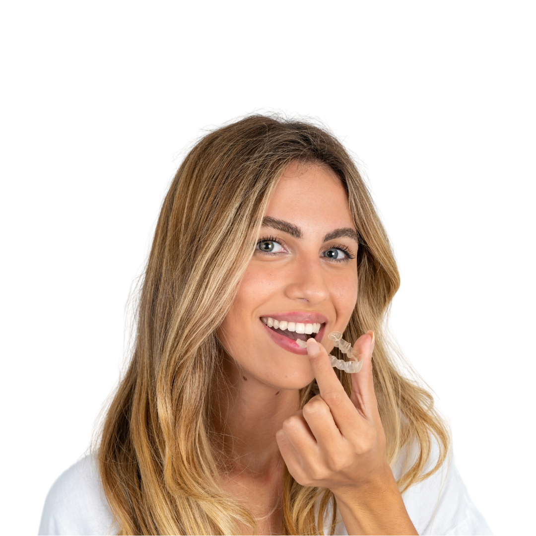 Adult woman holding clear aligners and smiling, highlighting Invisalign® treatment at Shine Ortho Studio.