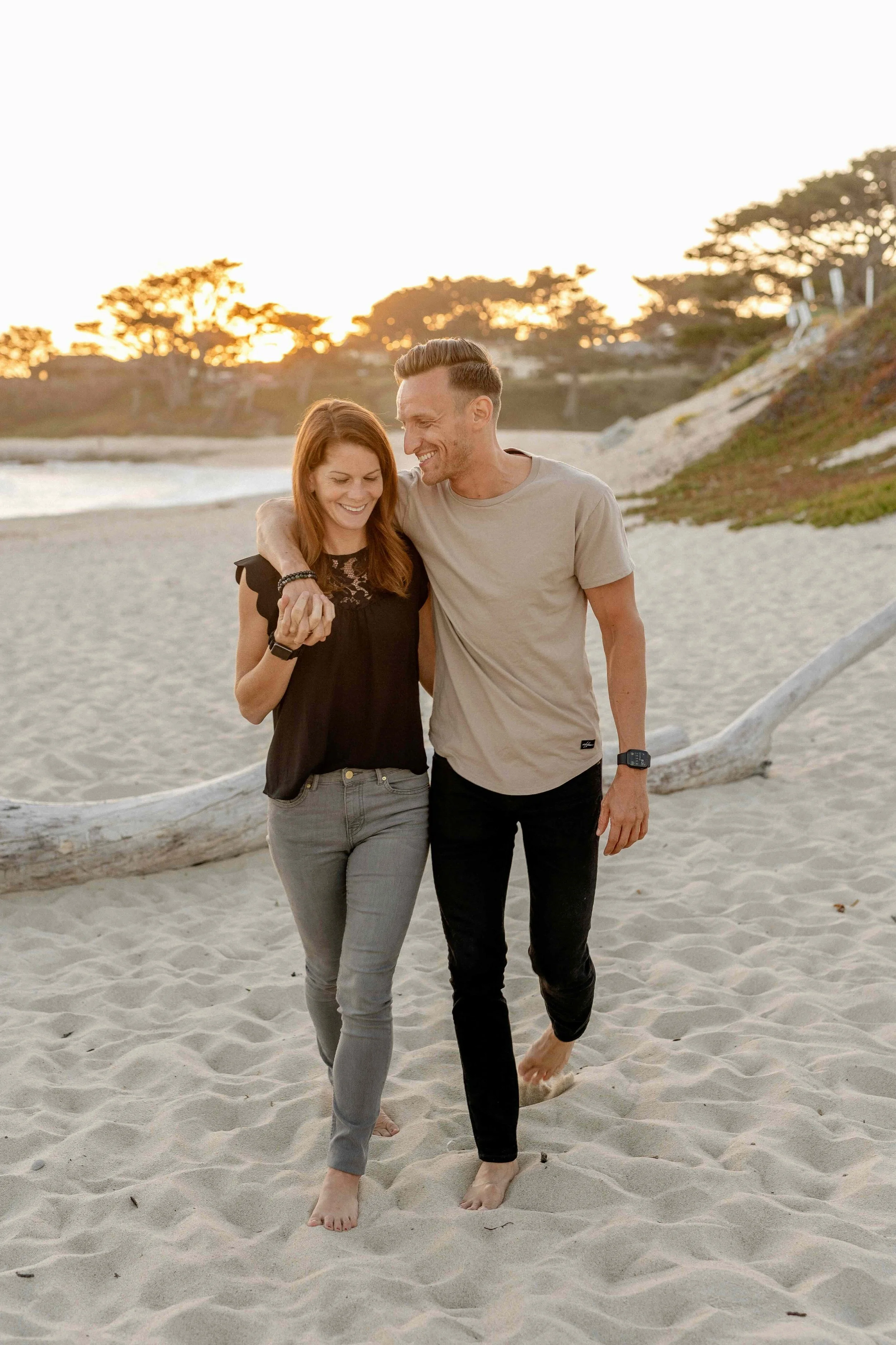 Couple walks along the beach holding hands.