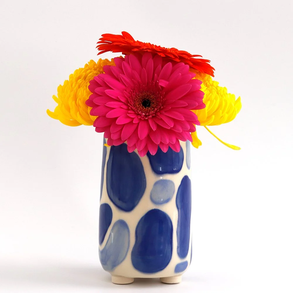 Colorful flower bouquet in a tall ceramic vase with blue and white pattern.