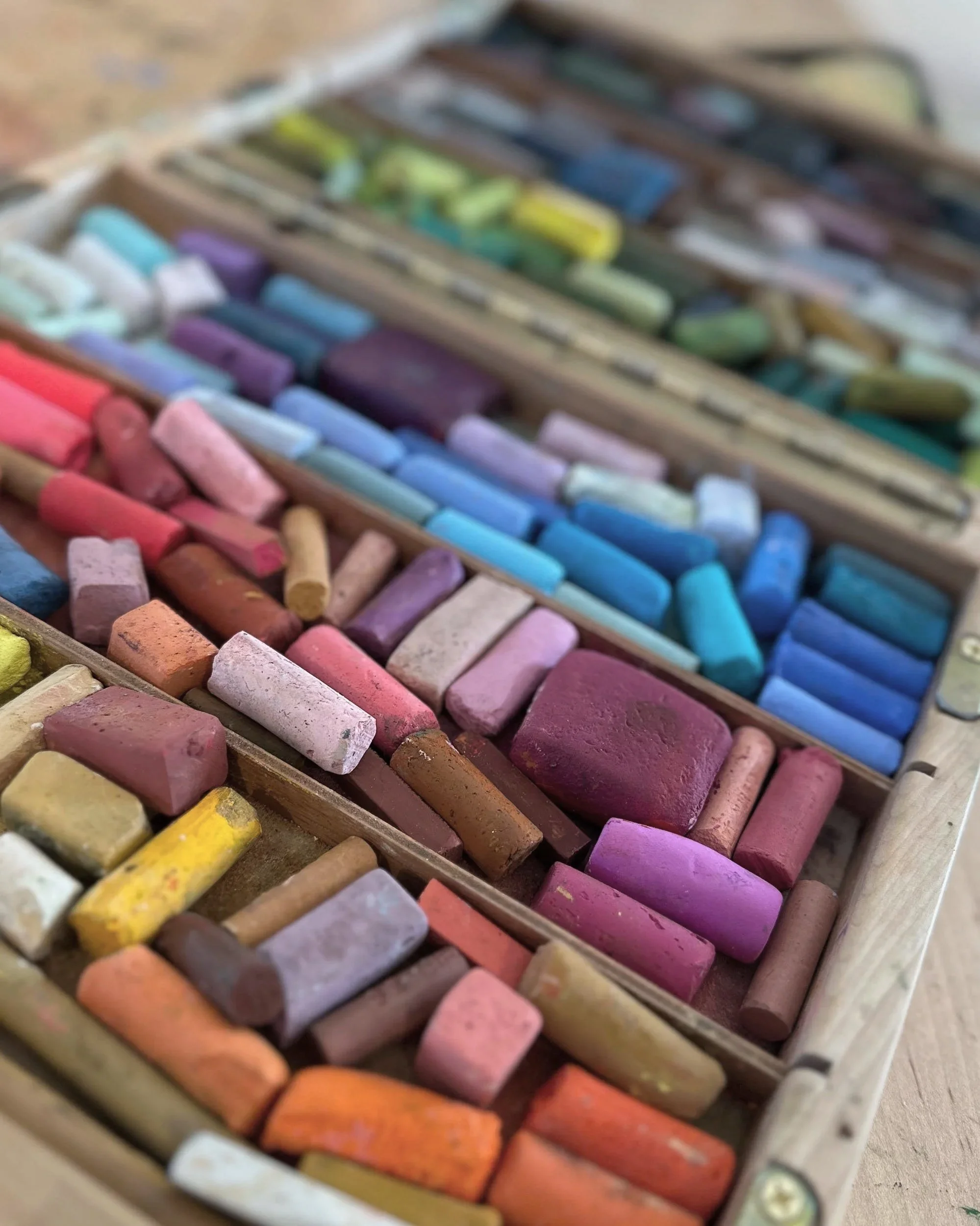 Box of colorful chalks arranged in rows.