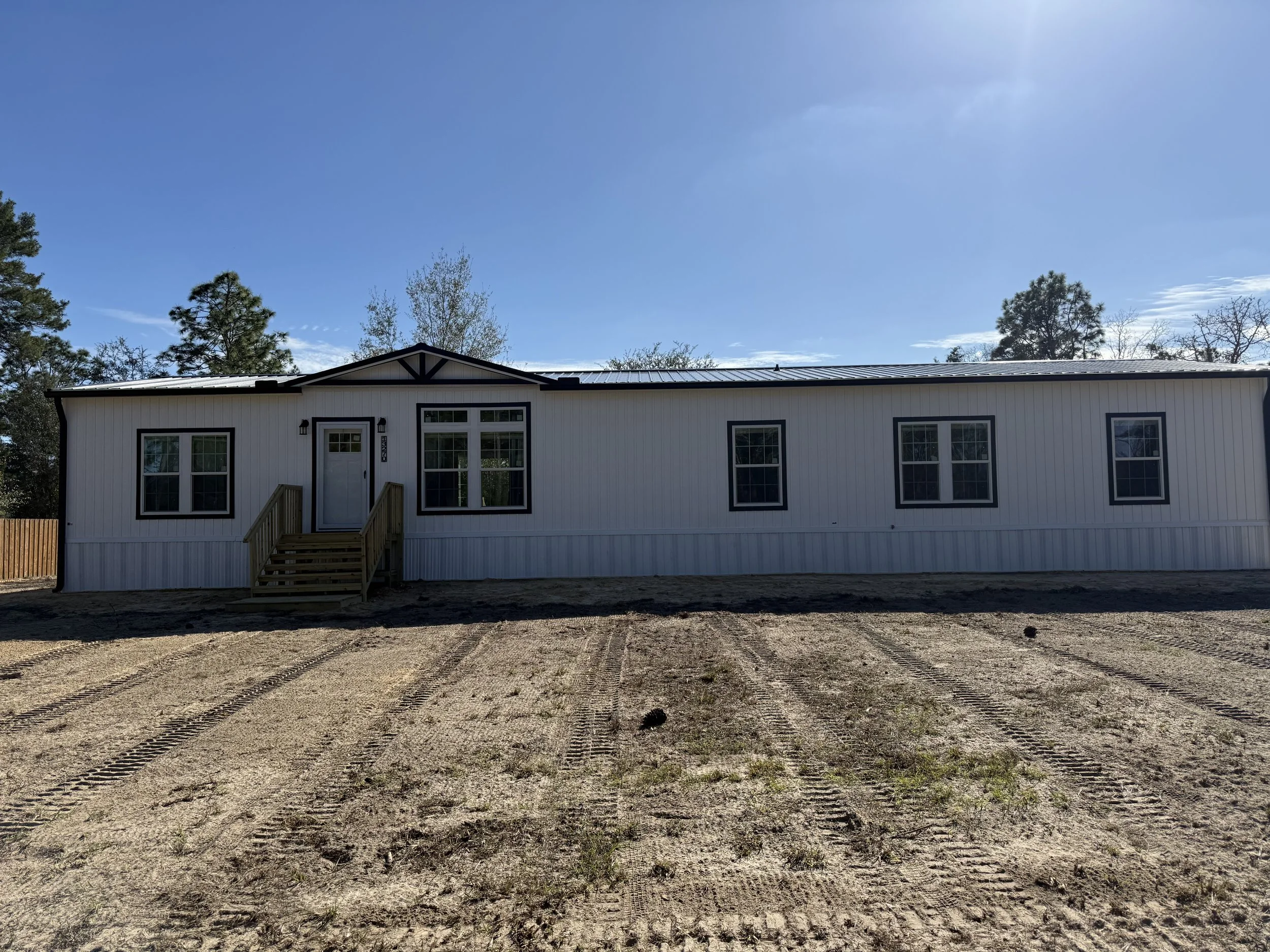 Black seamless gutters and downspouts installed on new mobile home in Williston, Florida