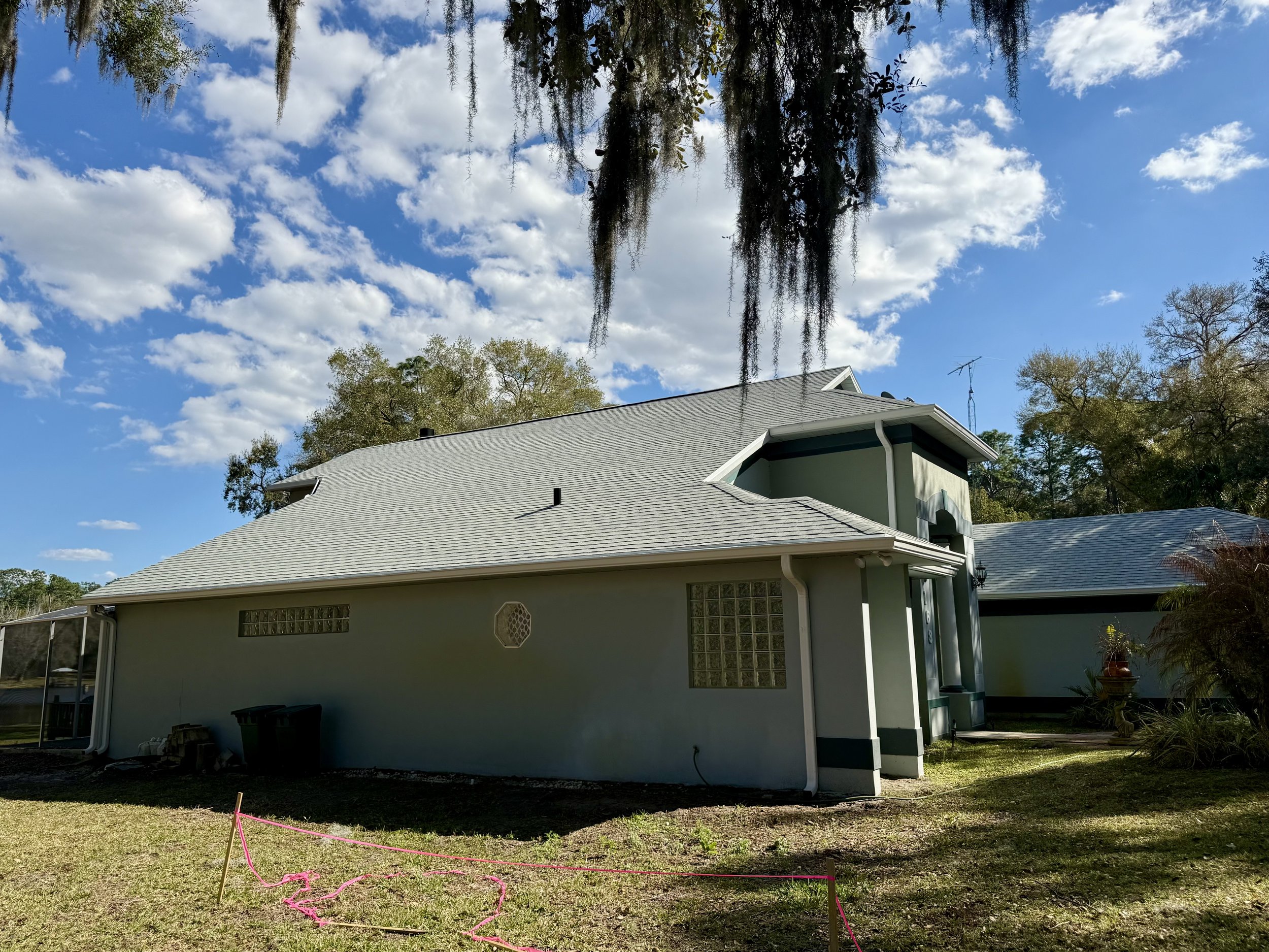 White seamless gutters and downspout installed along side of home in Sunset Pond, Mount Dora, Florida