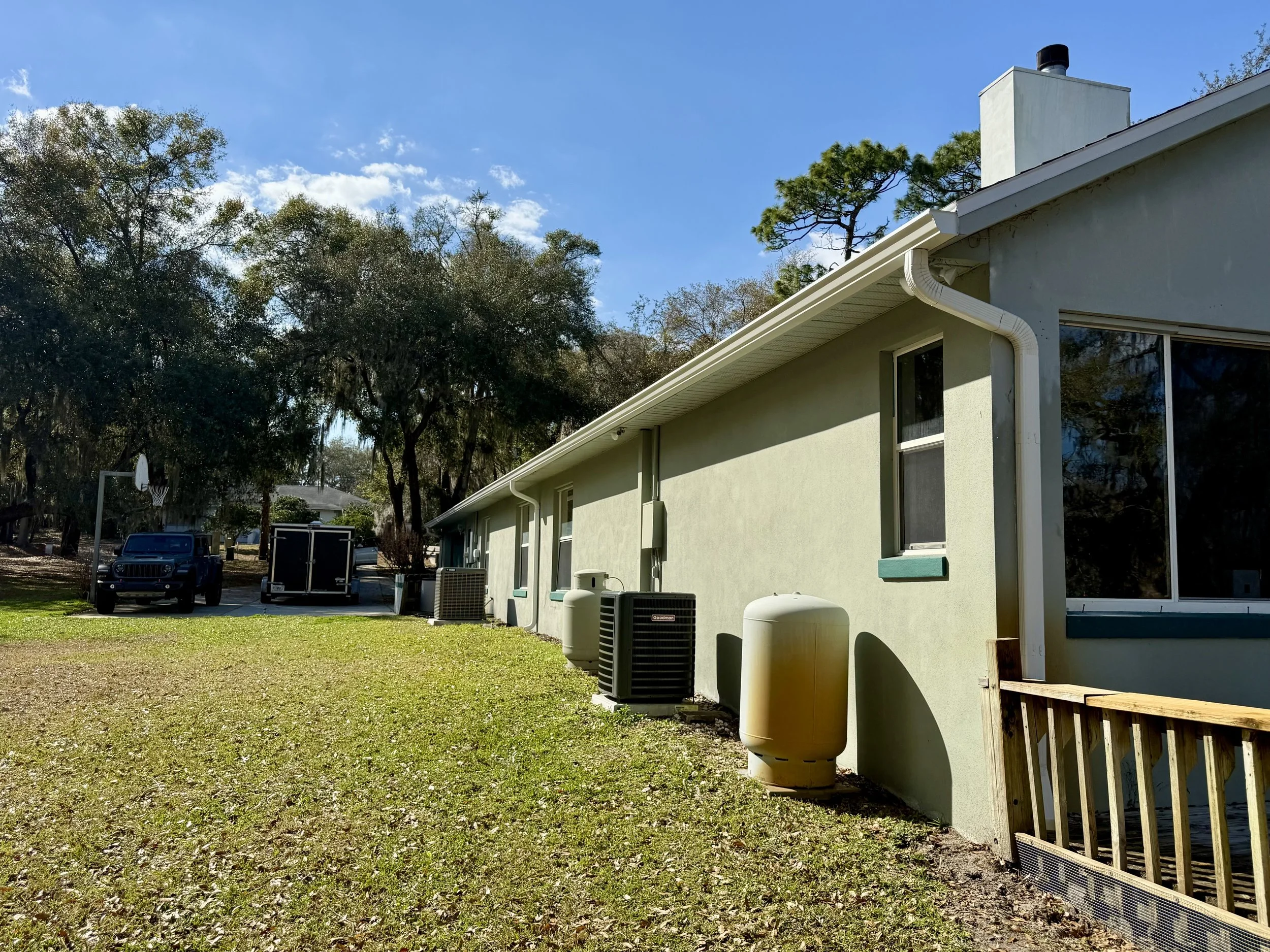 White seamless gutters and downspouts installed on side of waterfront home in Sunset Pond, Mount Dora, Florida