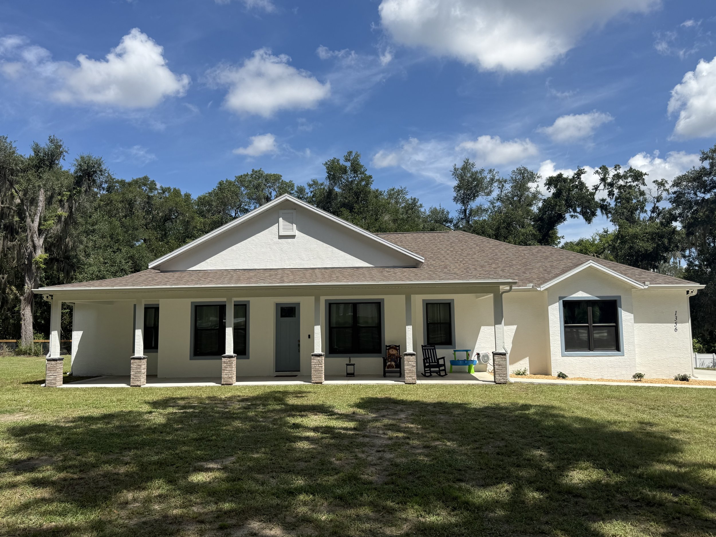 Front exterior of a Fruitland Park, FL home with new white seamless gutters installed along the roofline.
