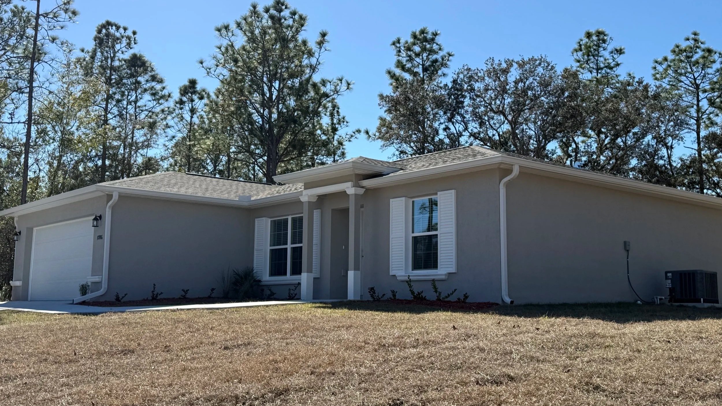White seamless gutters installed on a stucco home in Citrus Springs, Florida.