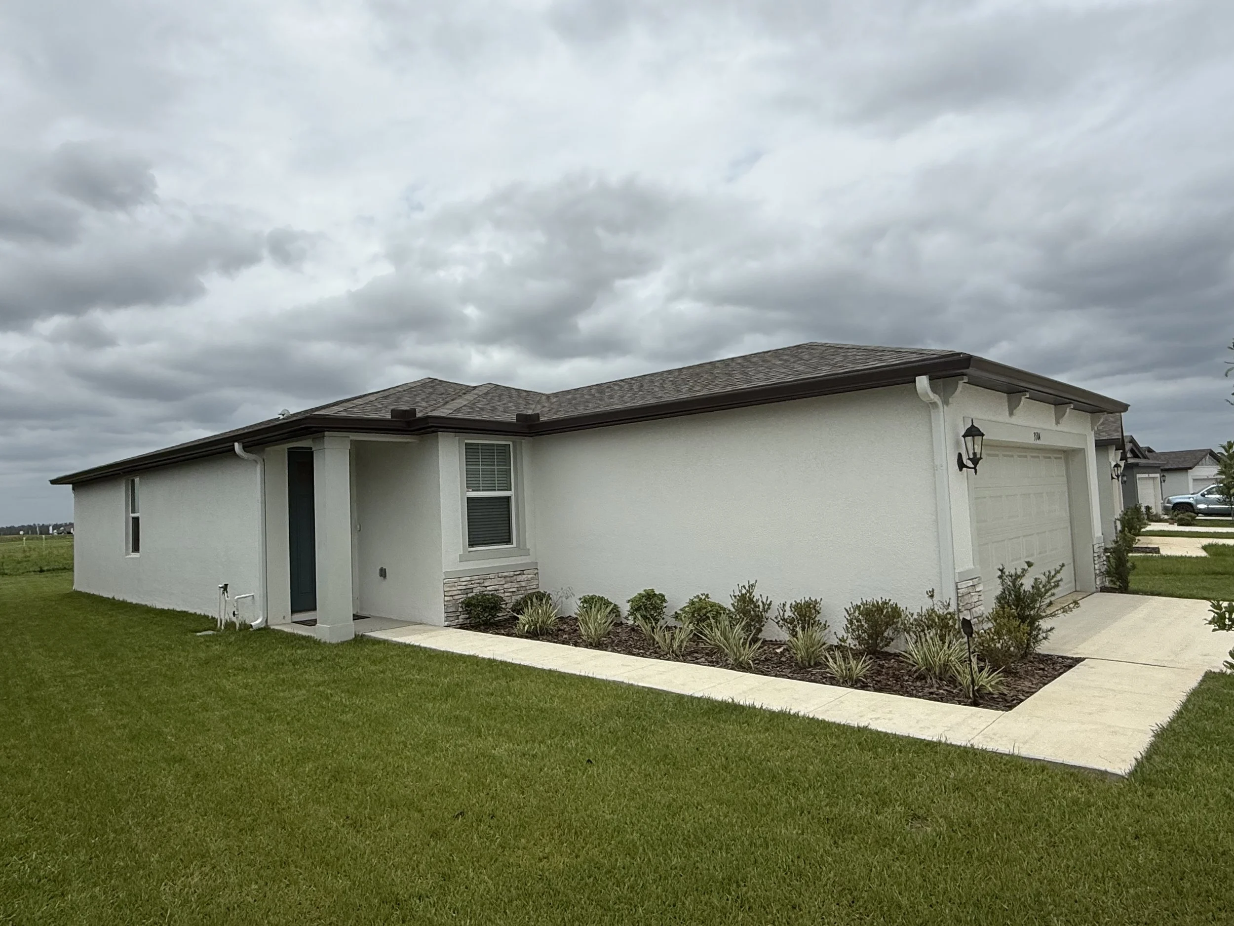 Musket Brown seamless gutters with white downspouts installed on home in Brooksville, Florida