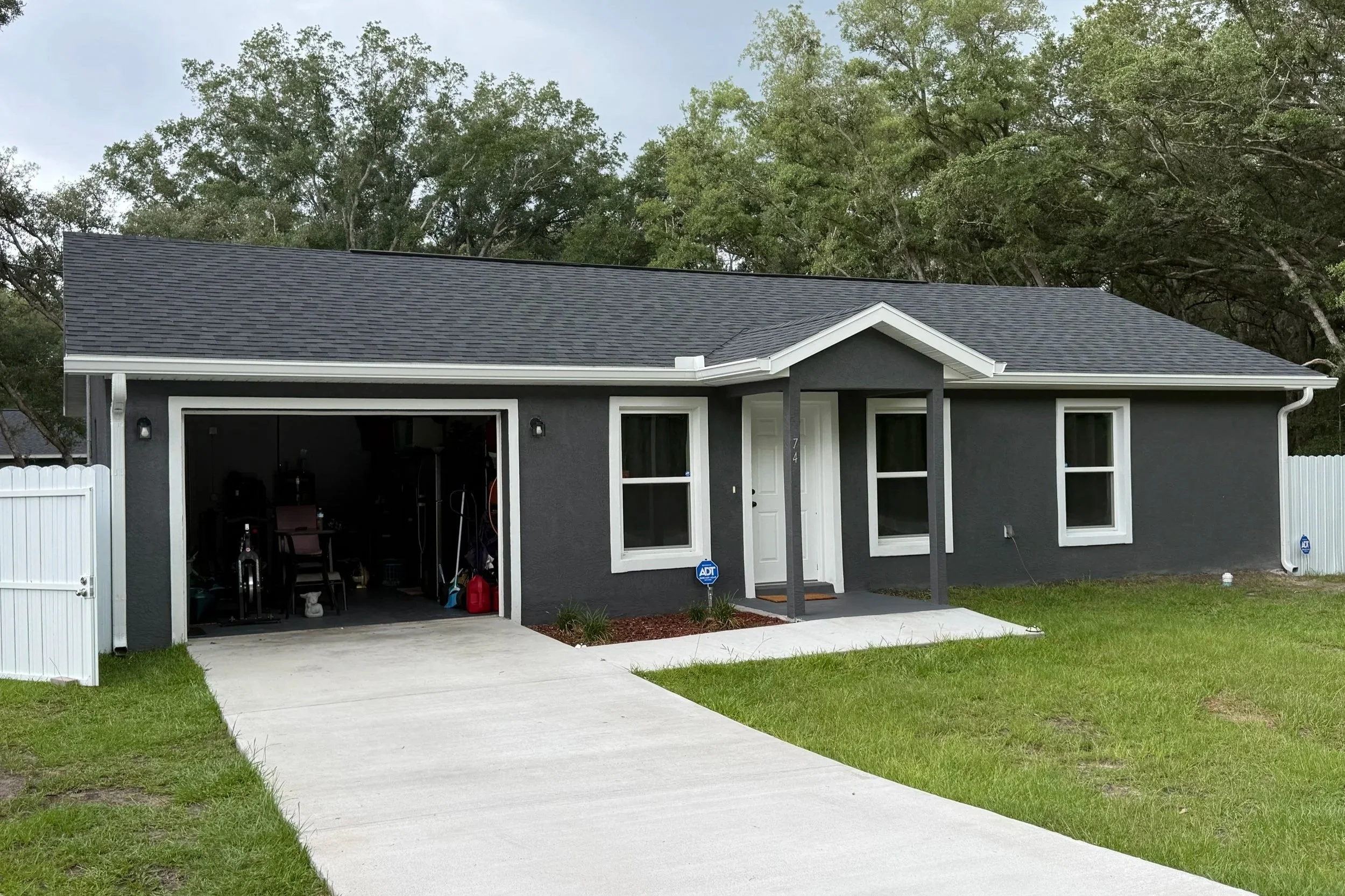 White seamless gutter installation on dark gray home in Ocklawaha, Florida