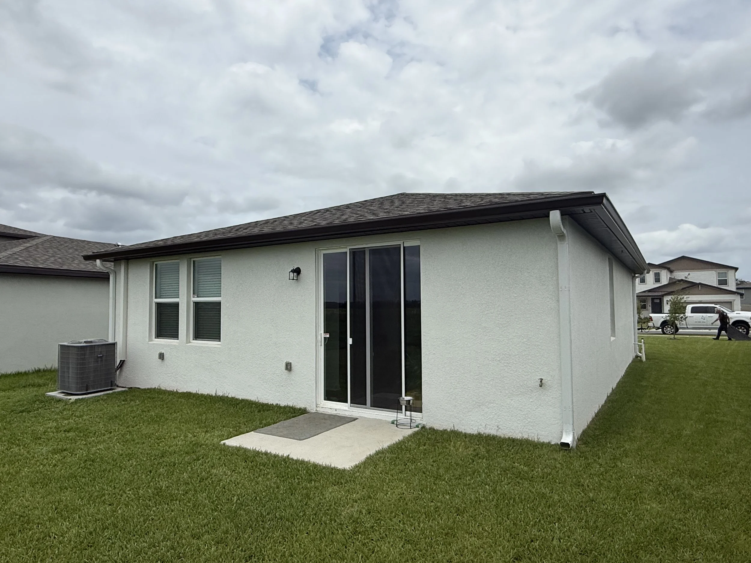 Musket Brown seamless gutters with white downspouts installed on home in Brooksville, Florida