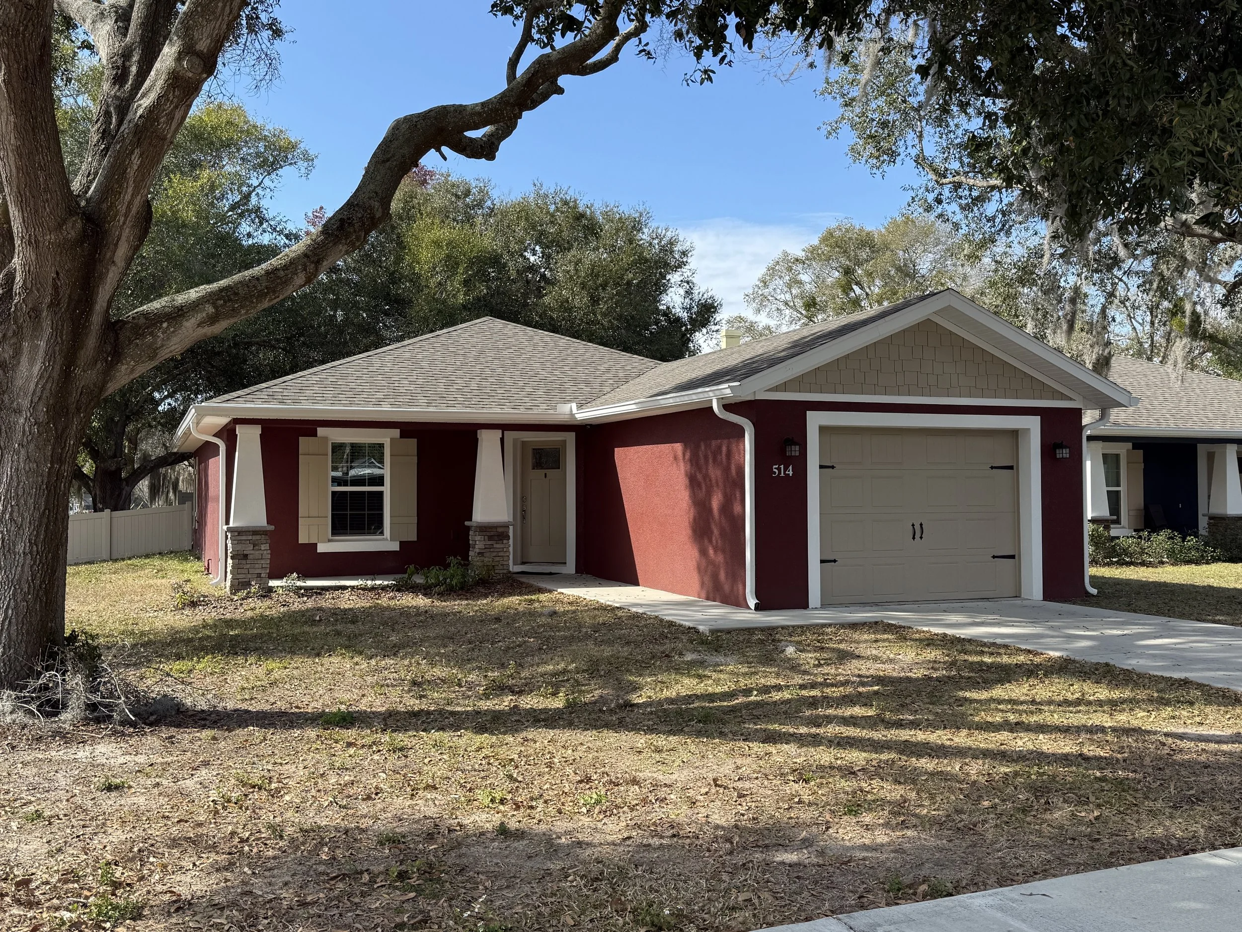 White seamless gutters and downspouts installed on red home in Eustis, Florida