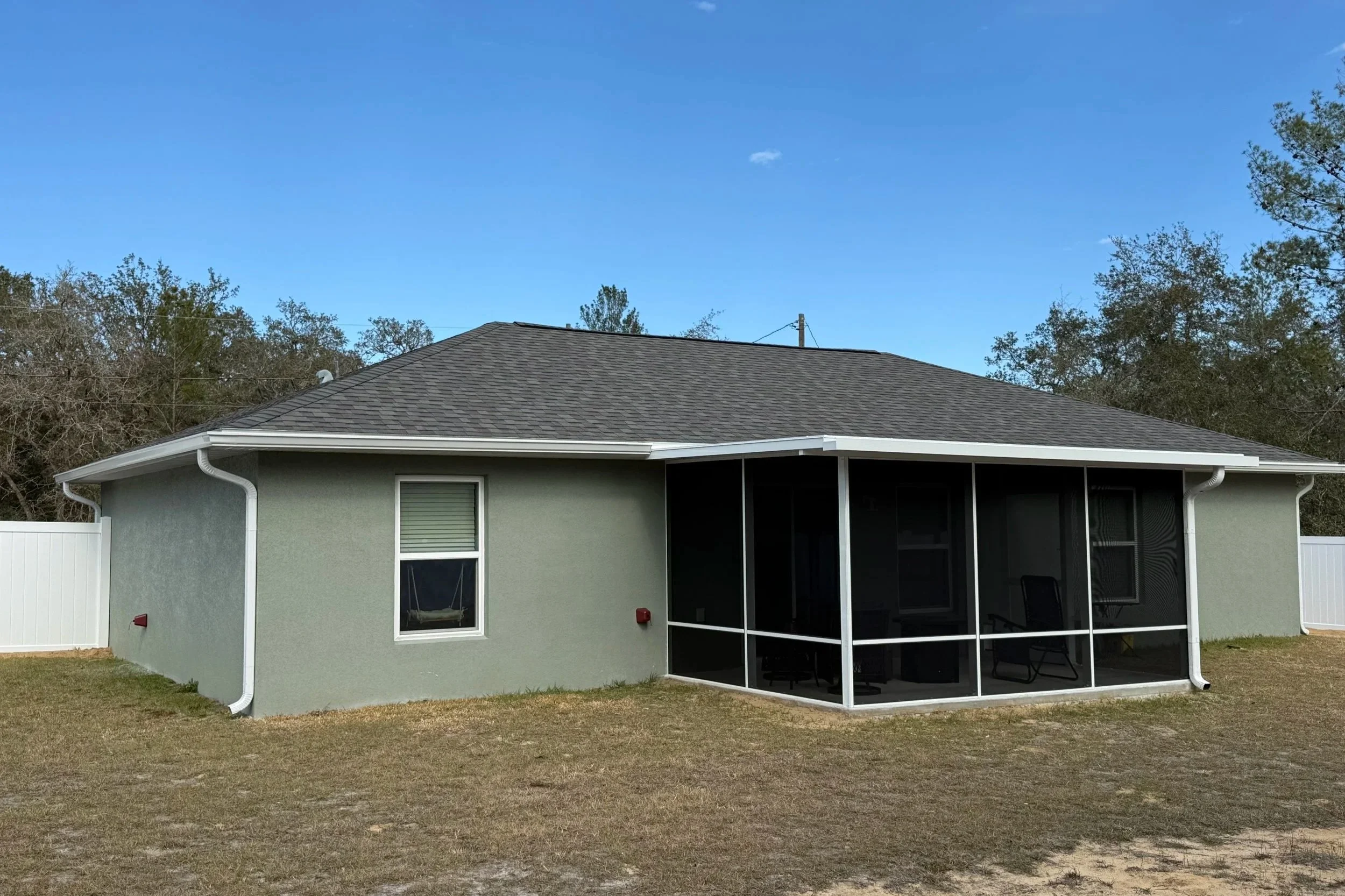 White seamless gutters installed on light gray home in Ocklawaha, Florida
