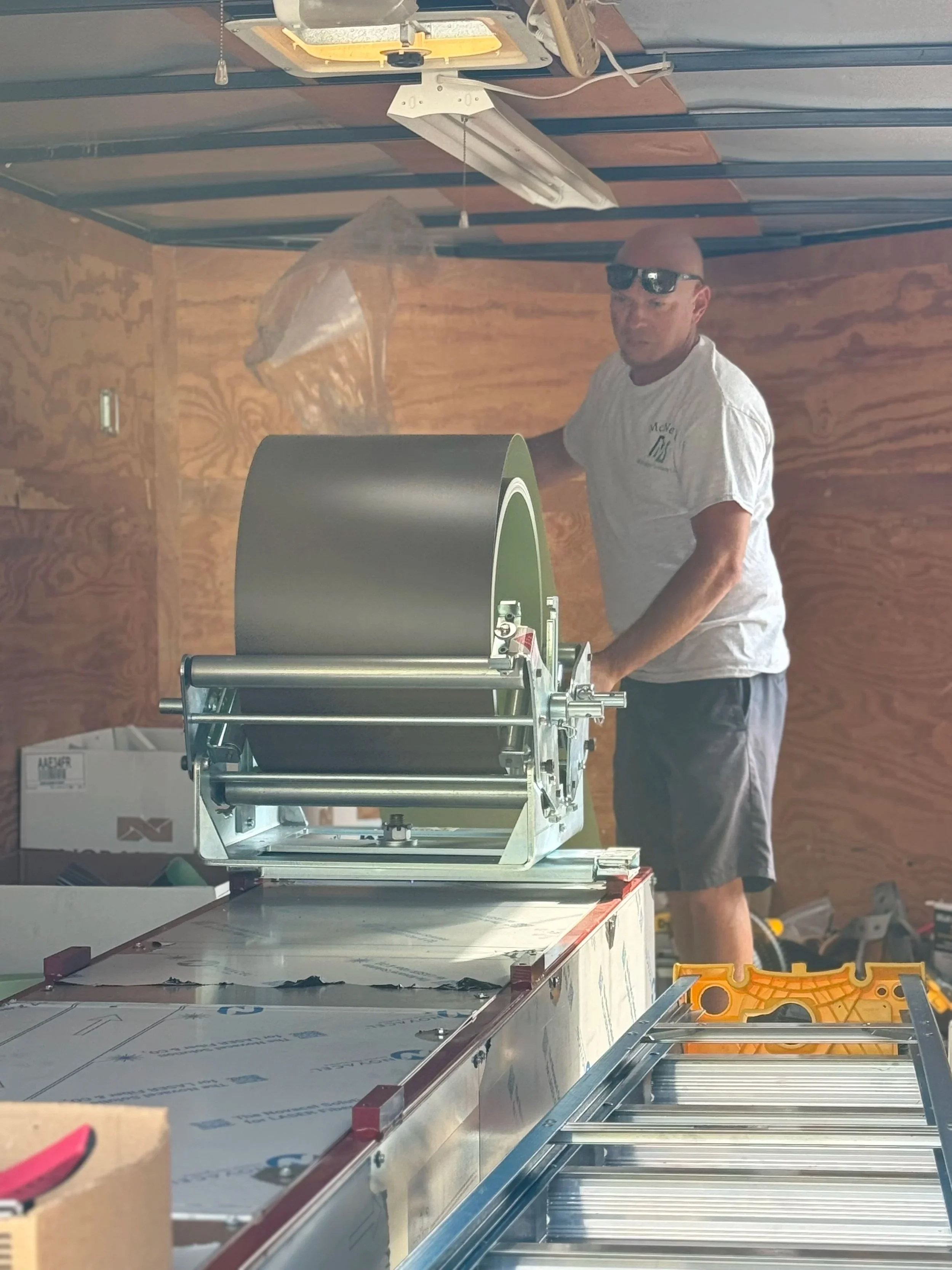 Danny McNeal working with the gutter machine to form seamless gutters for a McNeal’s Seamless Gutters installation.