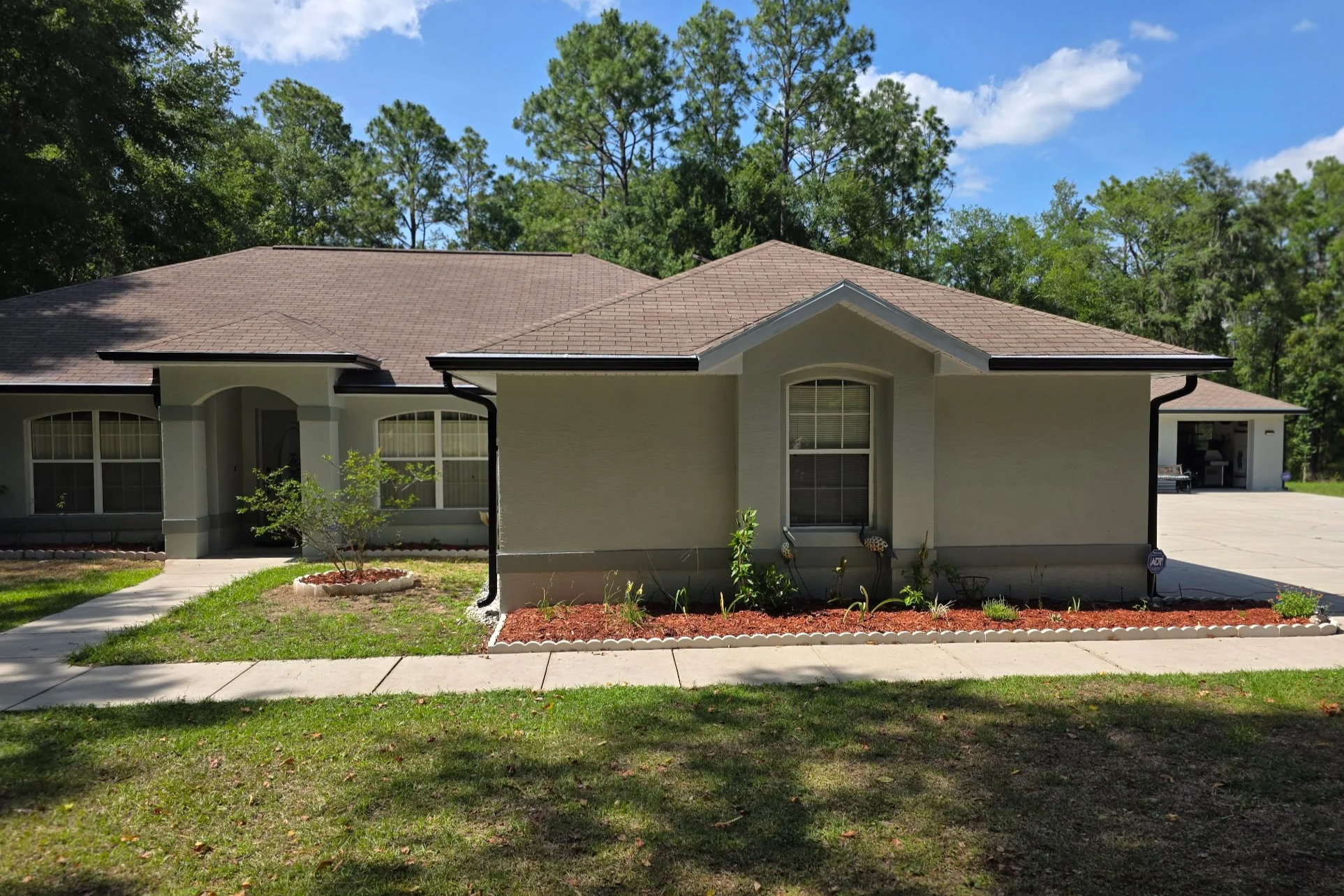 Dark Bronze seamless gutters installed on tan home in Dunnellon, Florida