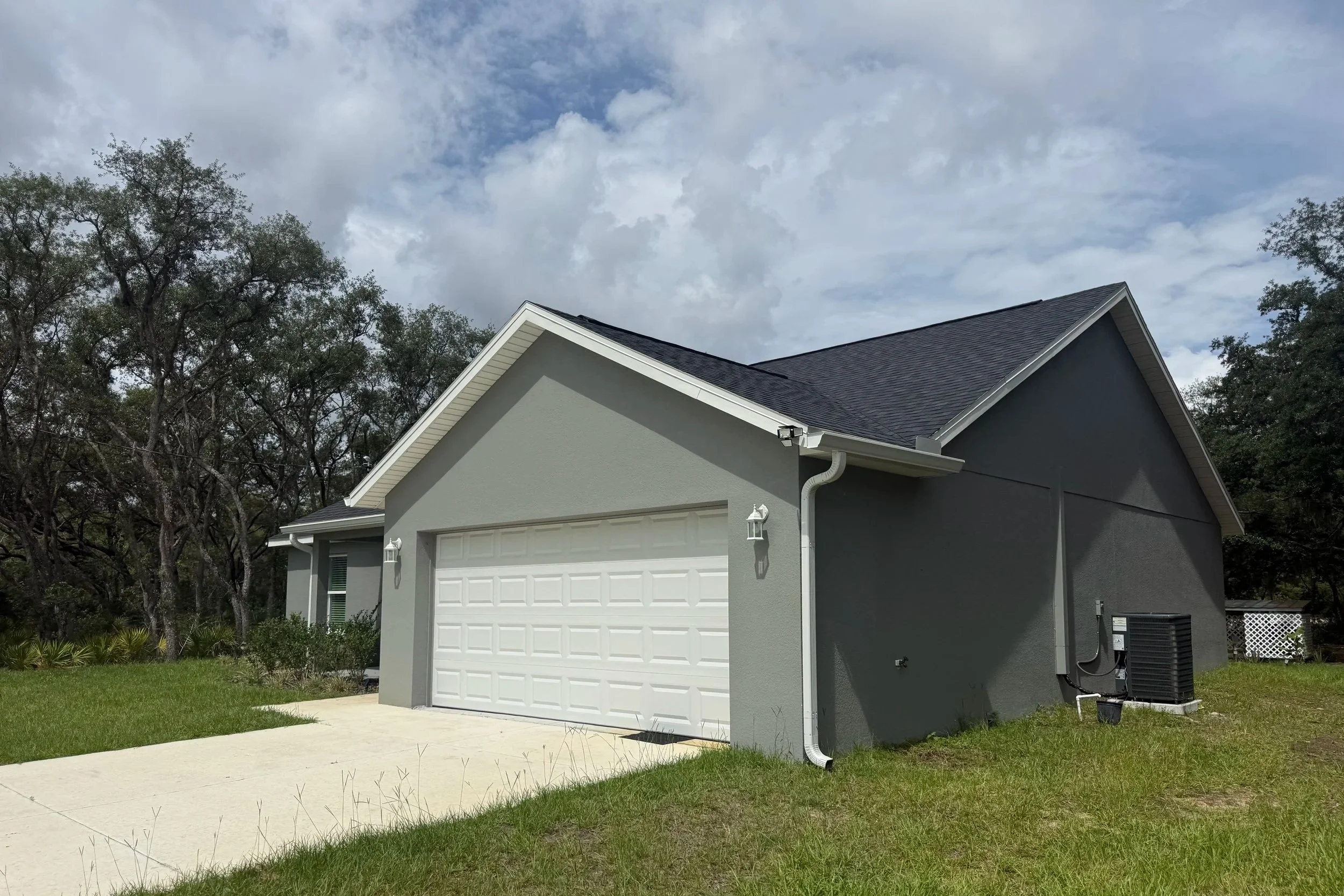 White seamless gutters and downspouts installed around screened patio on Ocklawaha home