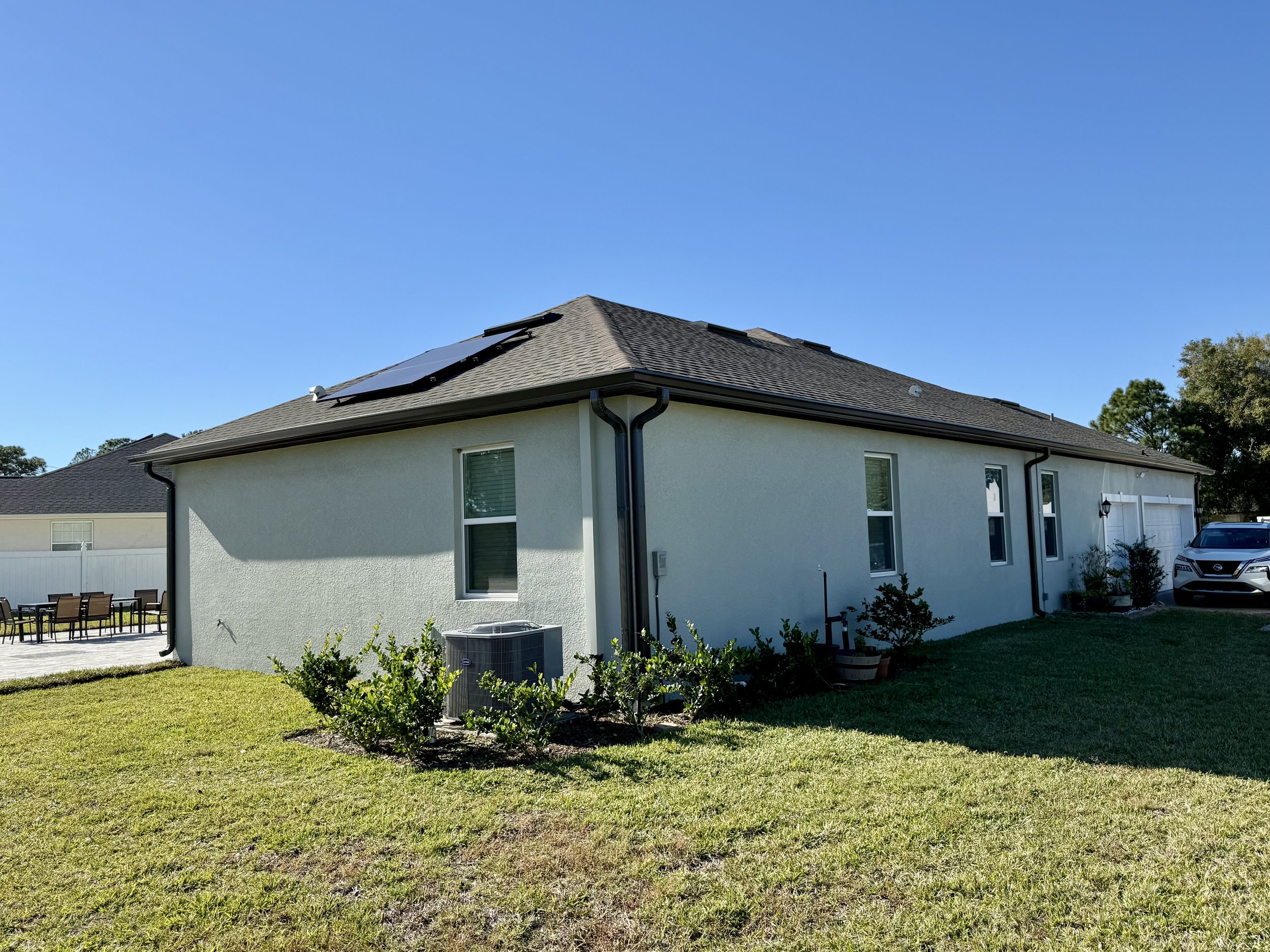 Dark Bronze seamless gutters and downspout installed on side of home in Magnolia Grove, Southeast Ocala, Florida