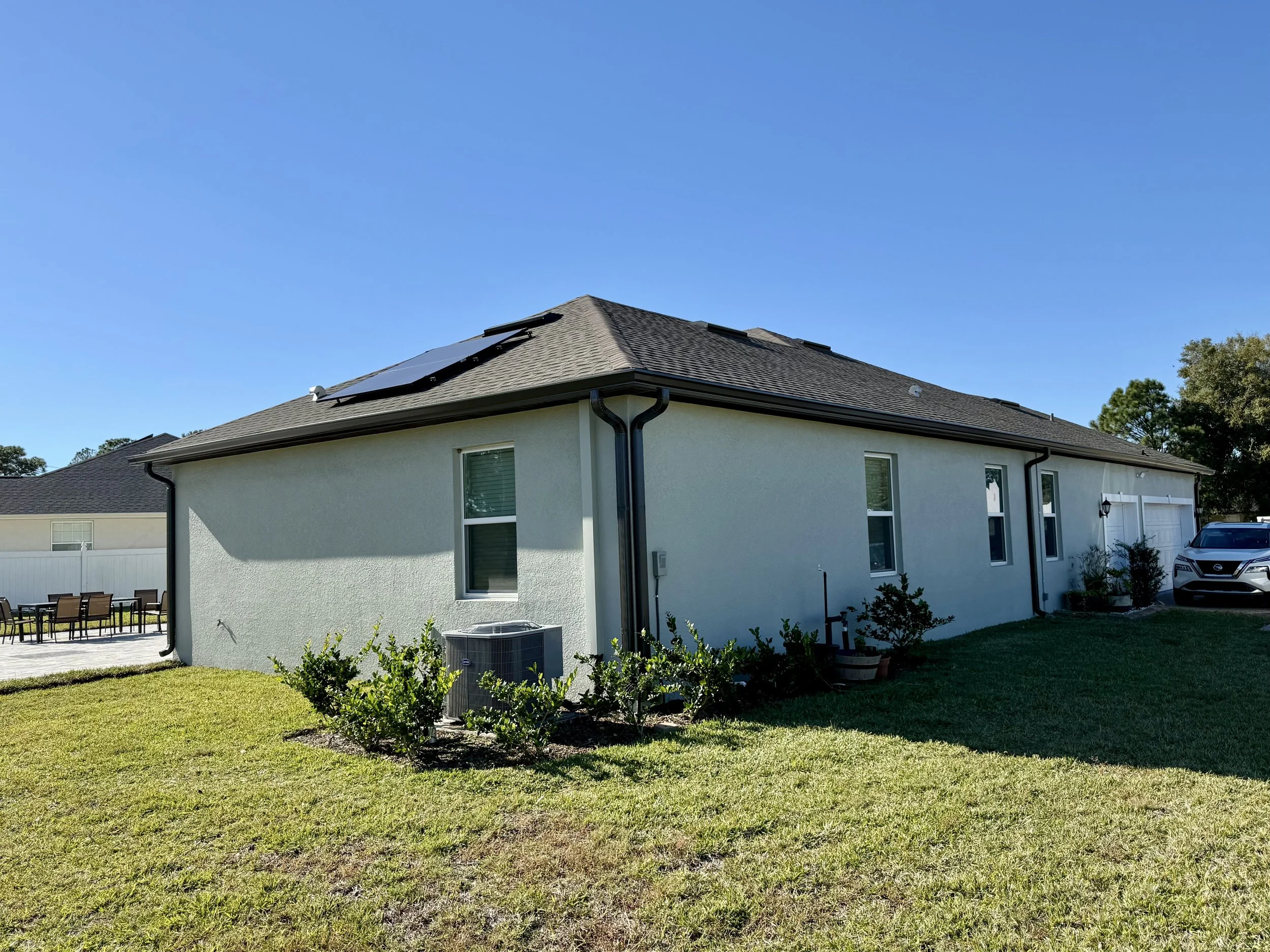 Dark Bronze seamless gutters and downspout installed on side of home in Magnolia Grove, Southeast Ocala, Florida