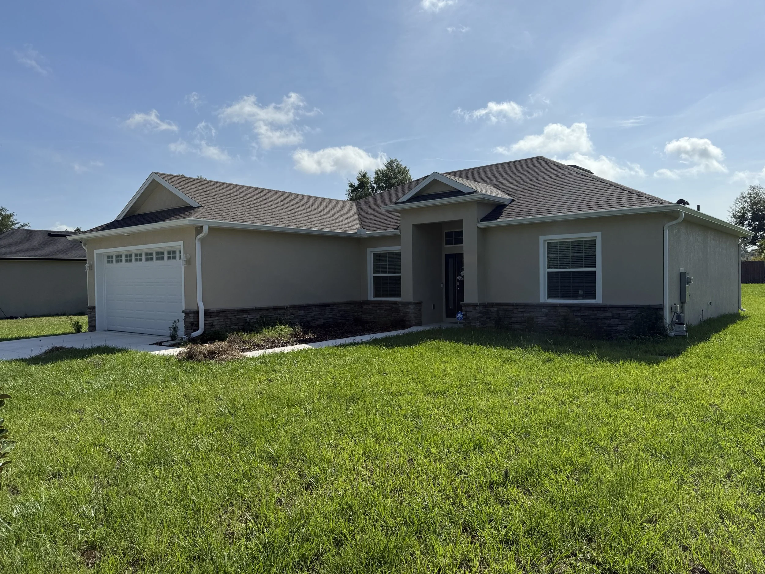 White seamless gutters installed on new construction home in Silver Beach Heights, Umatilla, Florida