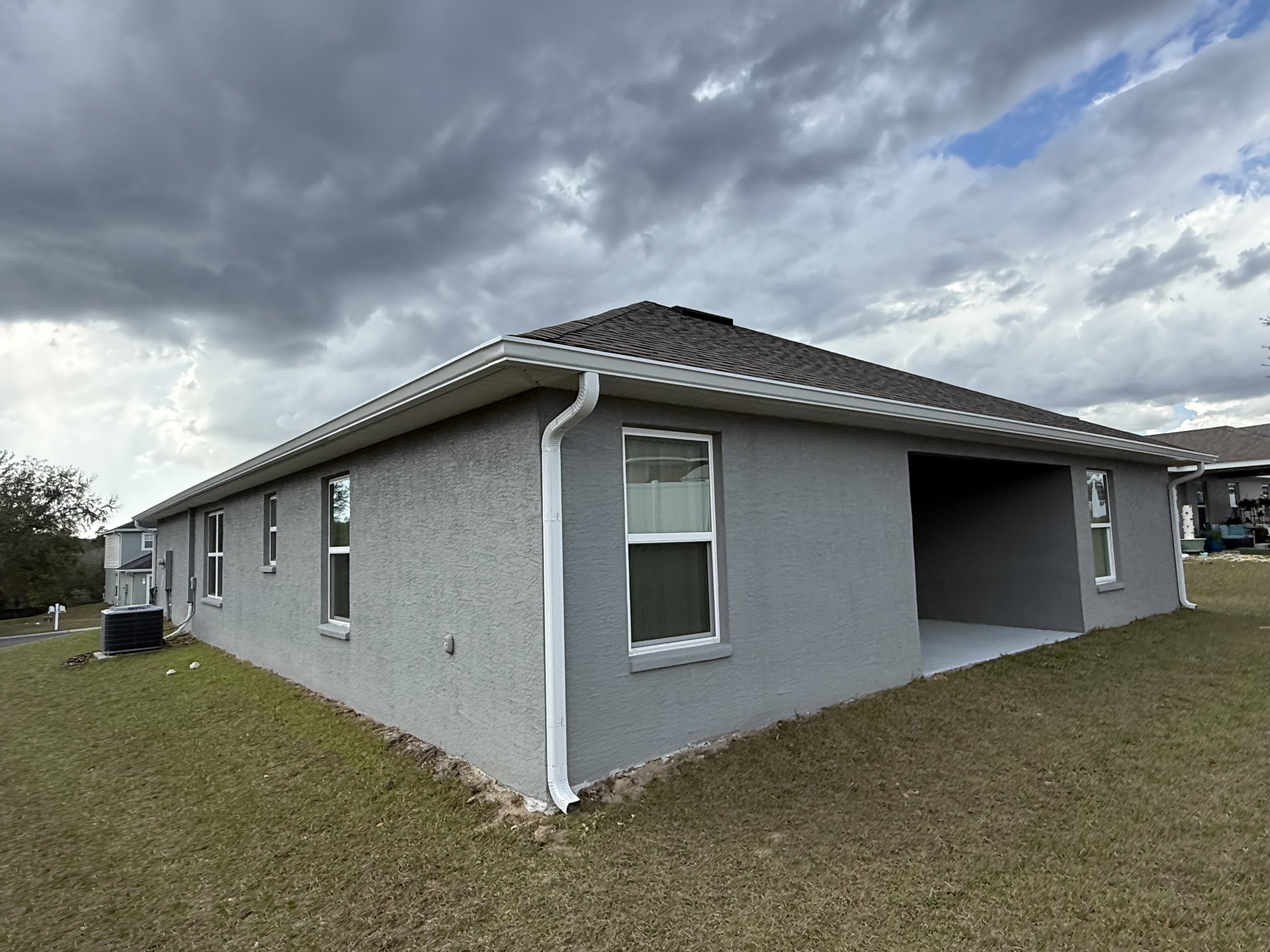 White seamless gutters and downspouts installed on home in Beverly Hills, Florida