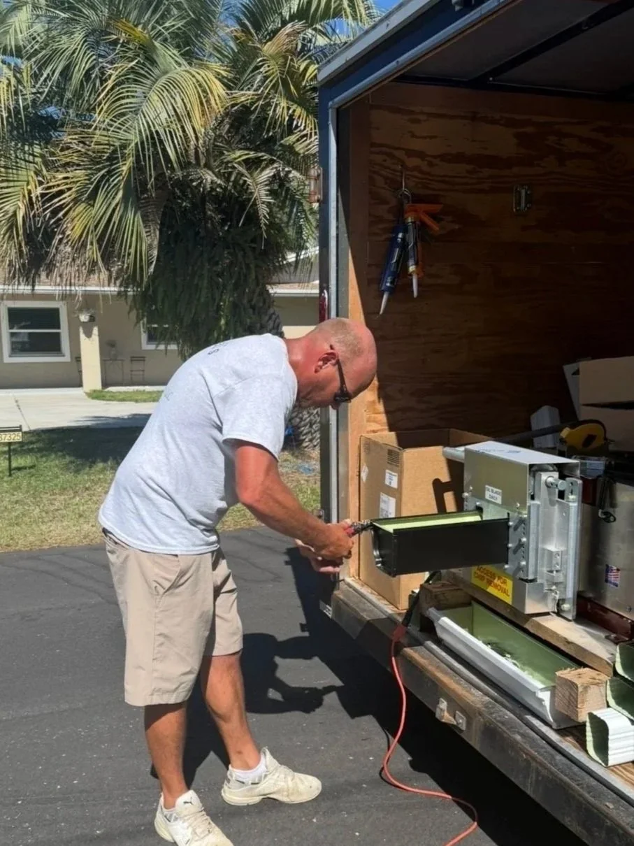 Close-up of seamless gutter being formed by a gutter machine and Danny McNeal the owner of McNeal's Seamless Gutters that is family owned and operated, showing freshly pressed aluminum ready for installation in Umatilla, Florida.