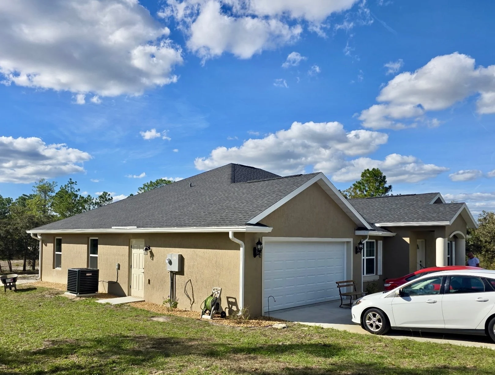 White seamless gutters and downspouts installed on side of home in Rolling Hills, Dunnellon, Florida