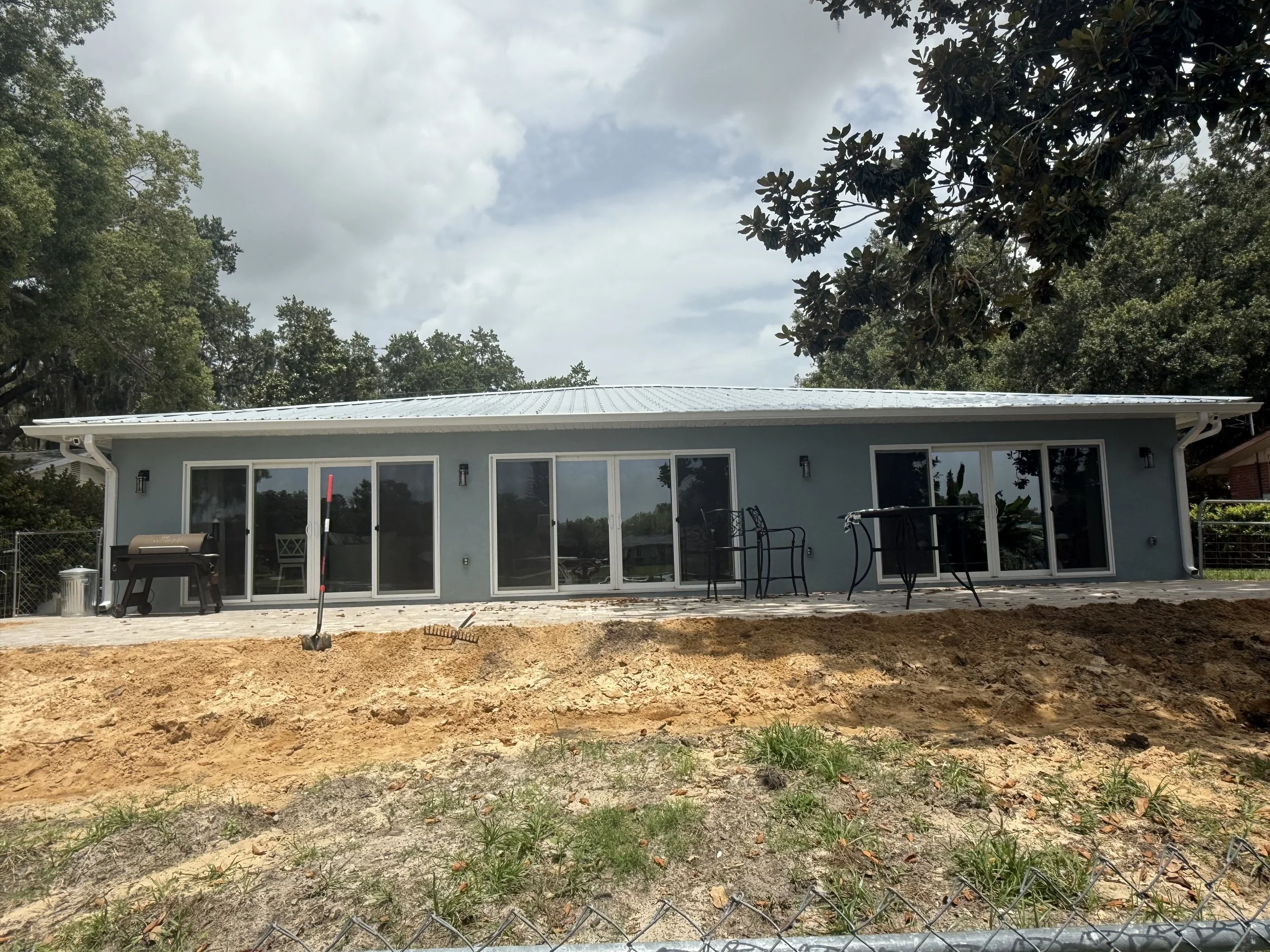 White seamless gutters and downspouts installed on rear of waterfront home in Eustis, Florida