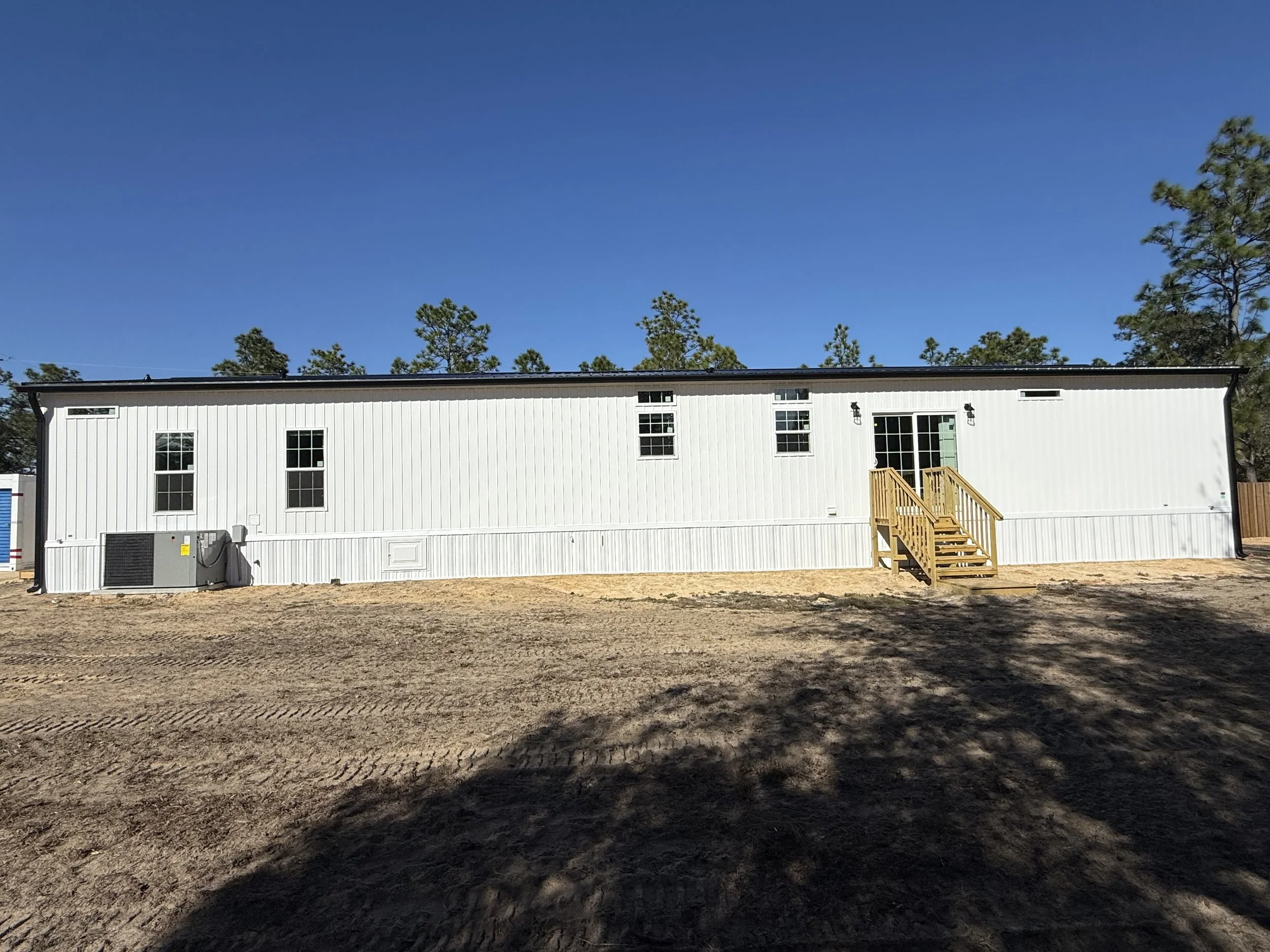 Black seamless gutters and downspouts installed on new mobile home in Williston, Florida
