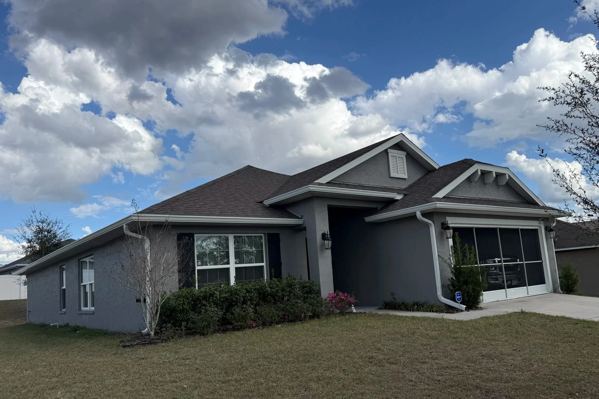 White seamless gutter installation on gray home in Dunnellon, Florida