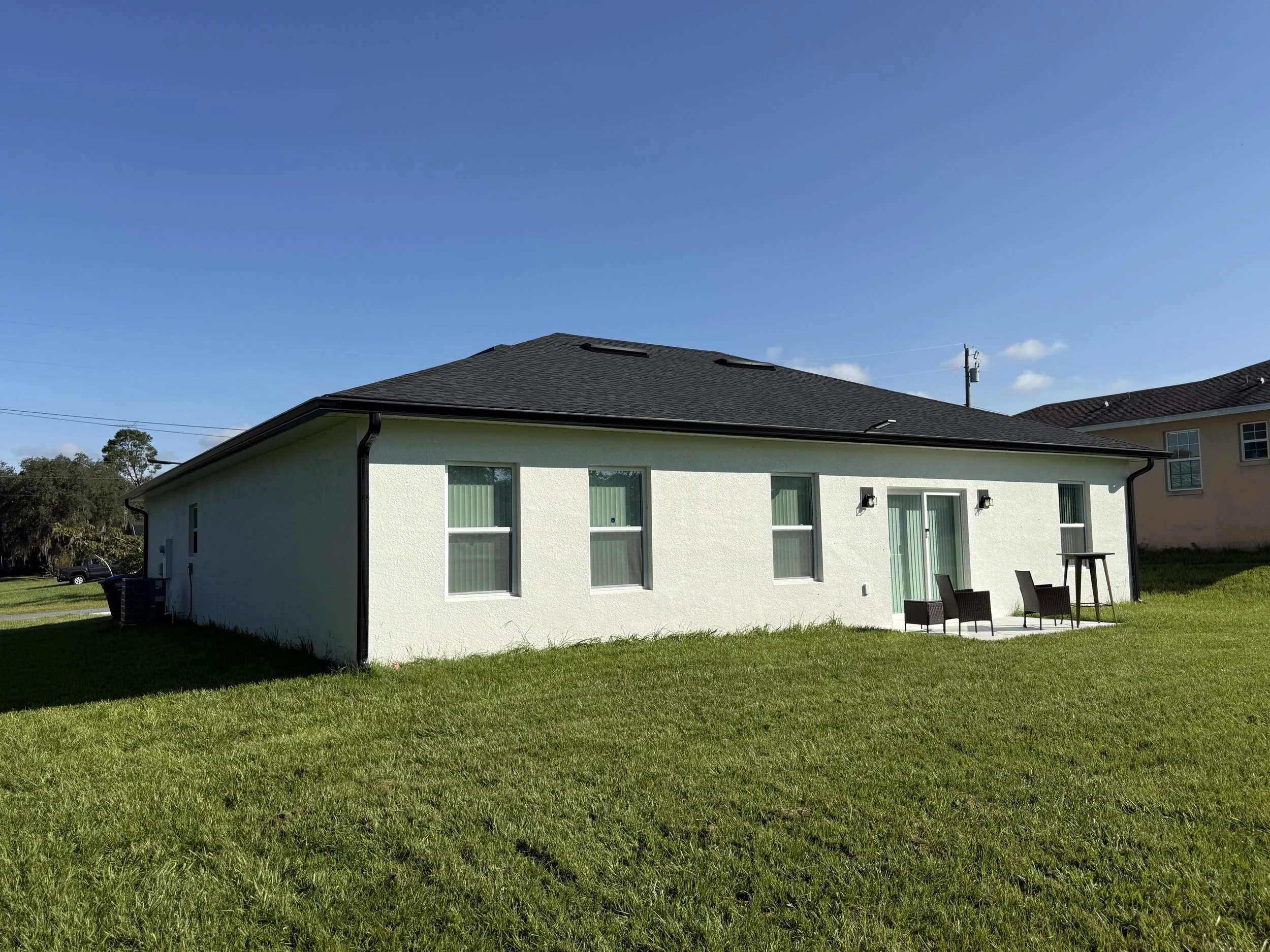Front view of a Marion Oaks, Ocala, FL home with black seamless gutters and downspouts complementing the black exterior accents.