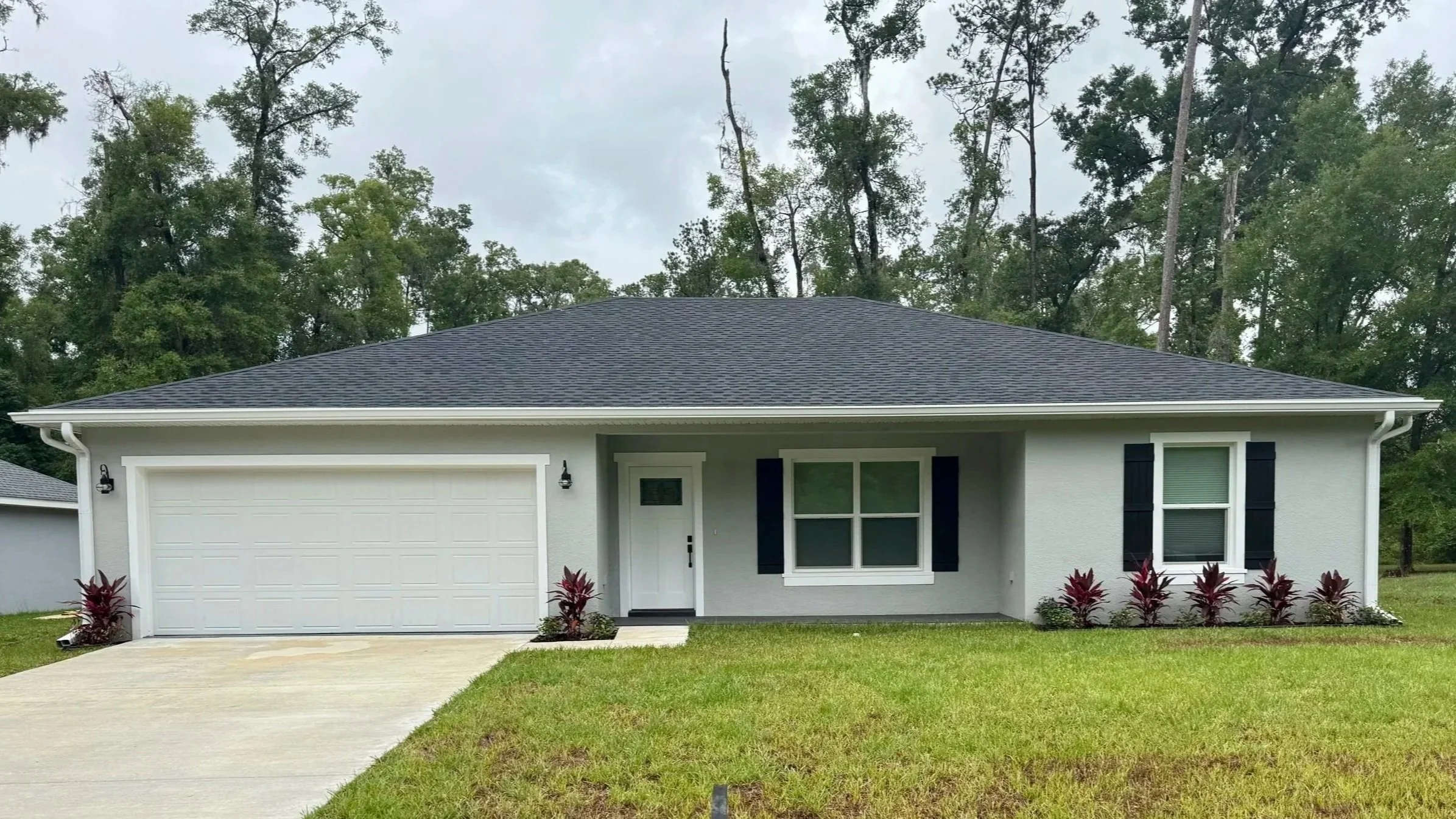 White seamless gutters installed on a gray home in Citrus Springs, Florida.