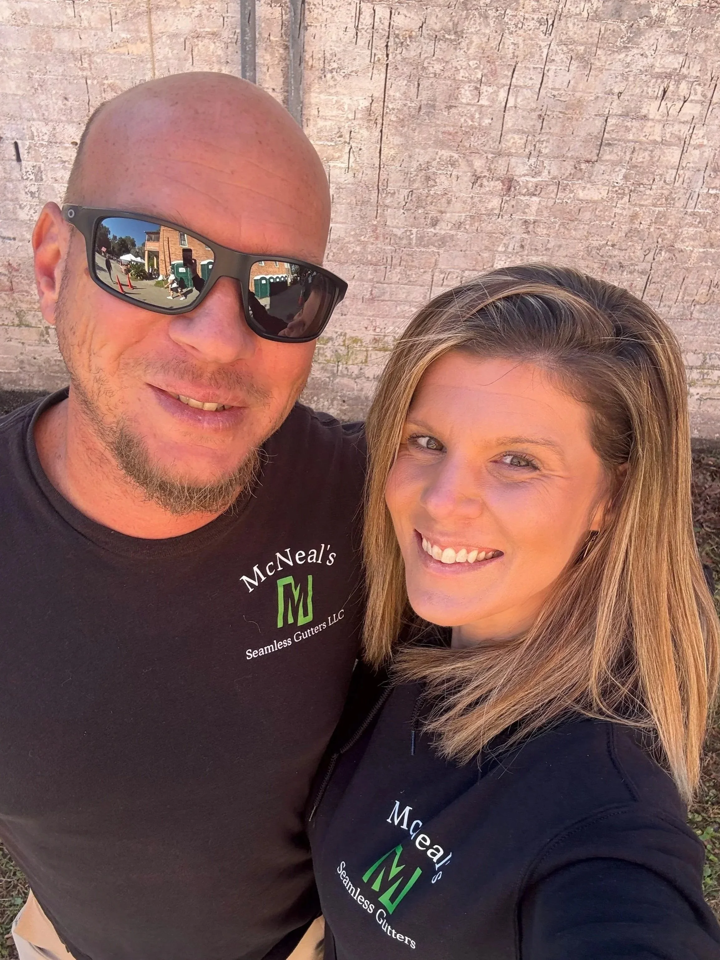 Danny and Danielle McNeal wearing McNeal’s Seamless Gutters shirts.