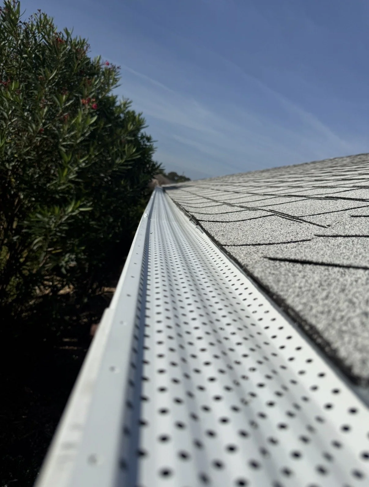 Close-up of seamless gutter gutter guard system with perforated gutter guard installed on a home roof, preventing leaves and debris from clogging gutters — work by McNeal’s Seamless Gutters LLC in The VIllages, Florida