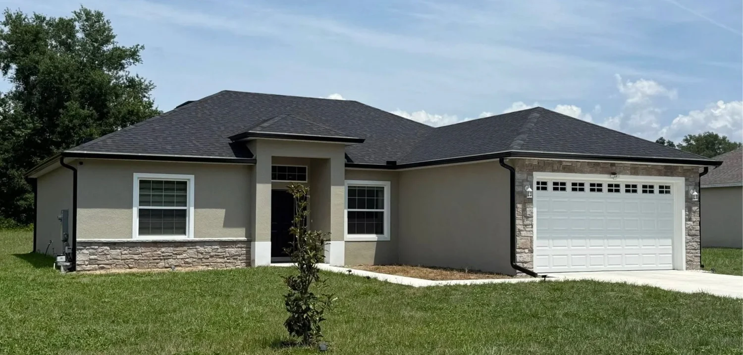 Black 6-inch seamless gutters and downspouts on a home in Umatilla, Florida, installed by McNeal’s Seamless Gutters.