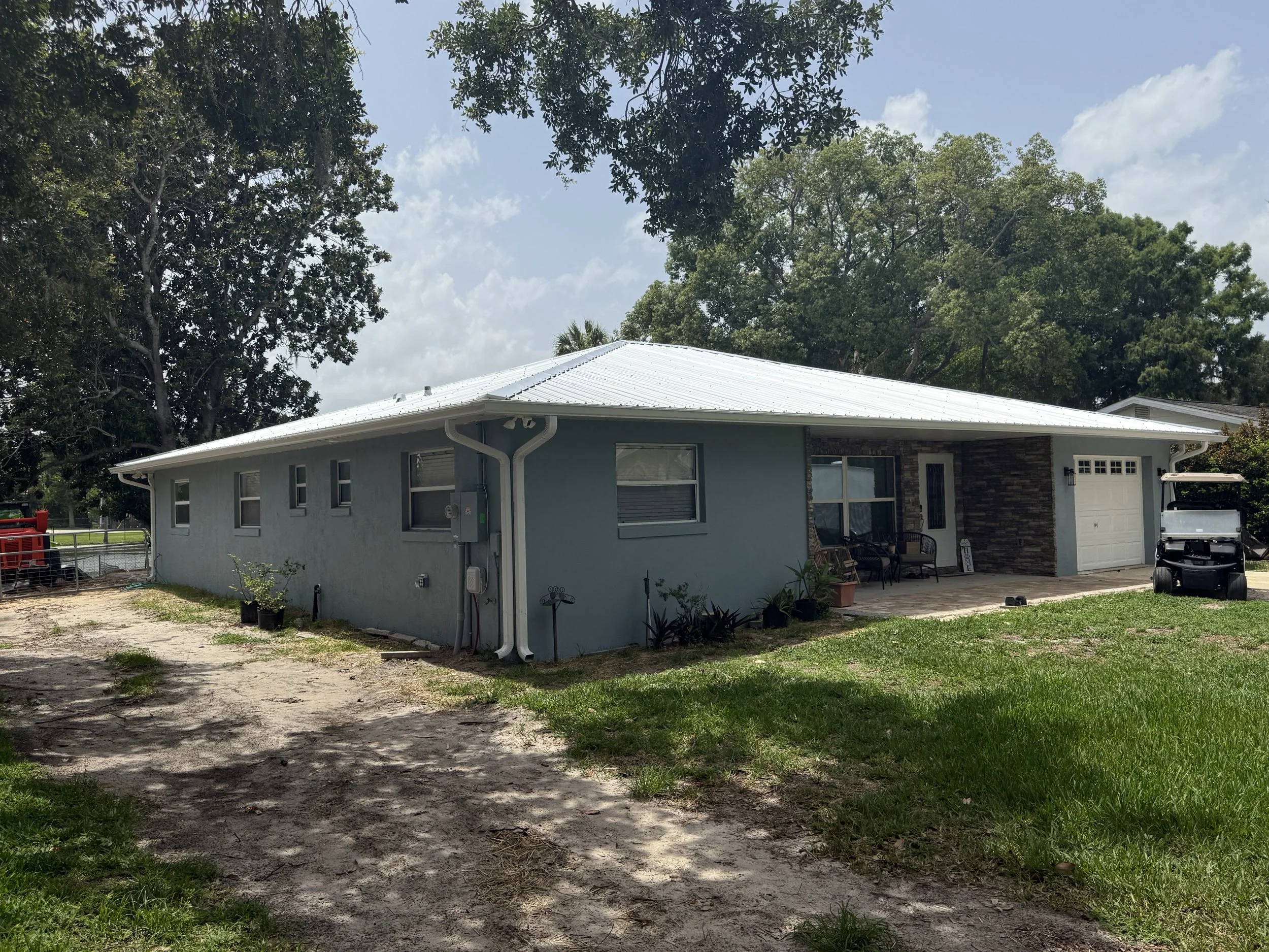 White seamless gutters installed on front of waterfront home in Eustis, Florida