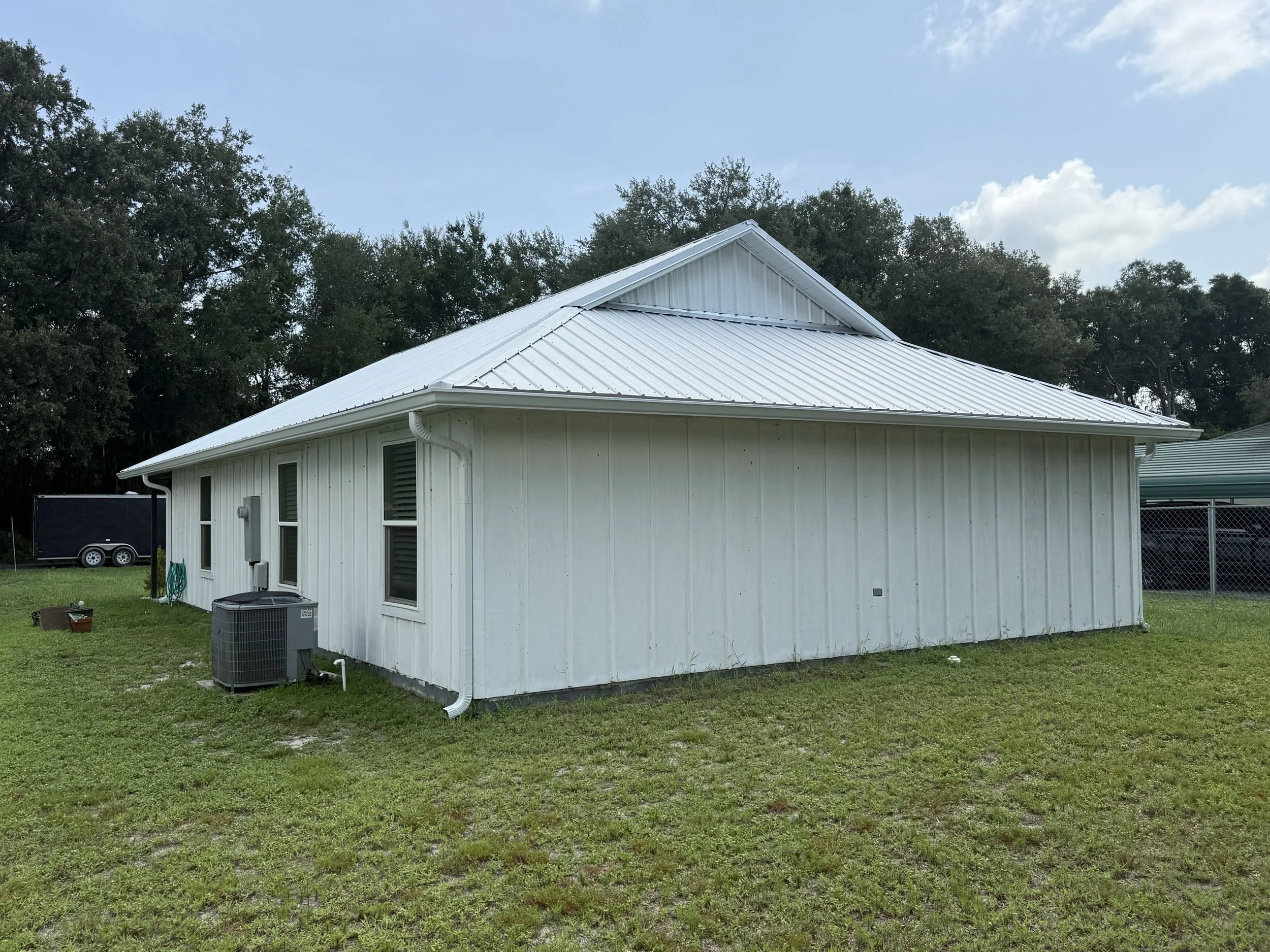 White seamless gutters and downspouts installed on home in Webster, Florida