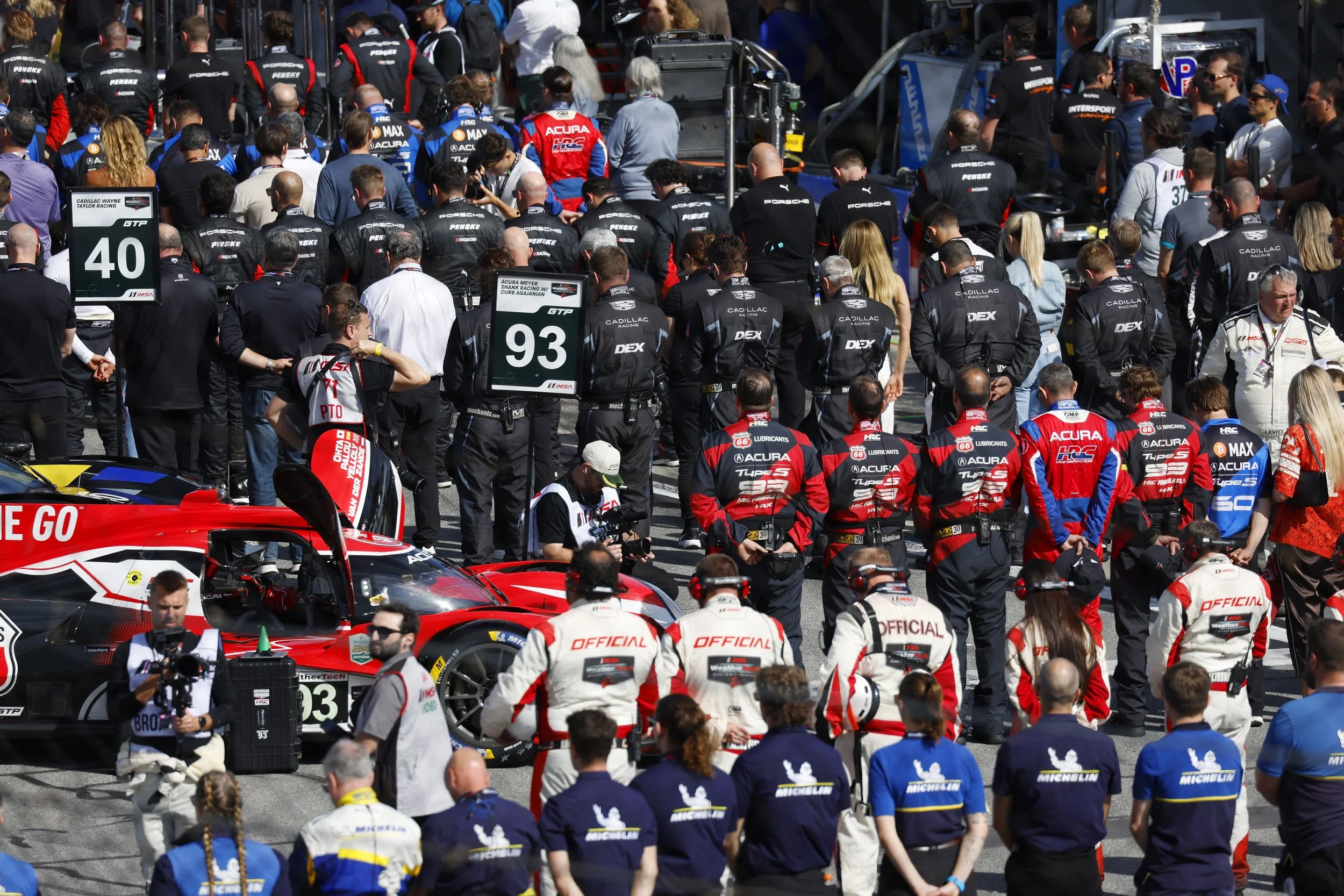 Race teams stand for the national anthem prior to the Rolex 24 Hours Daytona
