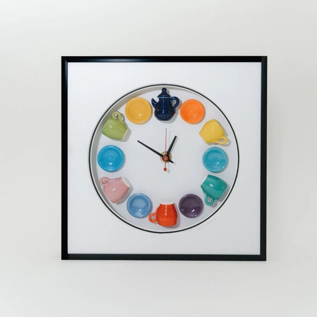 A wall clock with colorful teacups and saucers around its face, with black hour and minute hands and a red second hand.