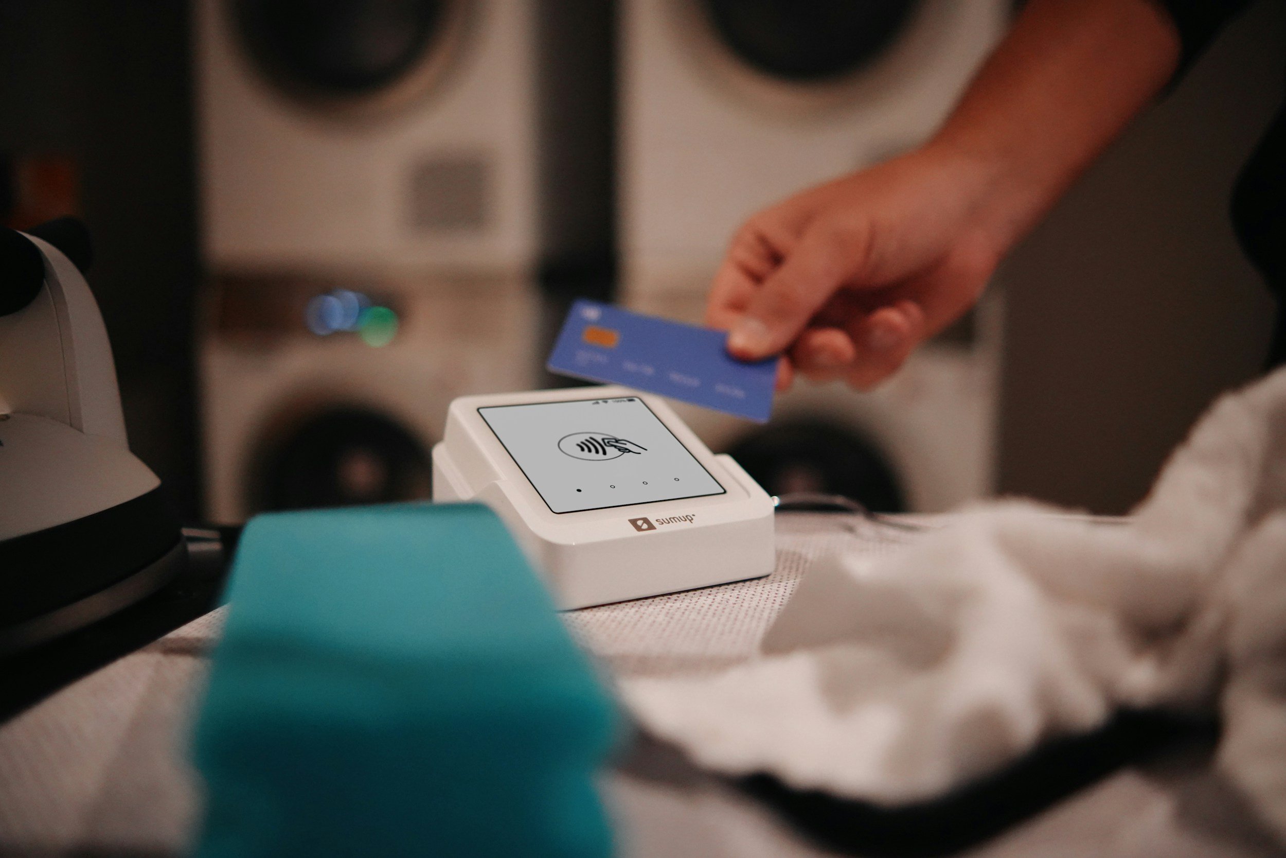 Person using a contactless payment terminal to swipe a credit card.