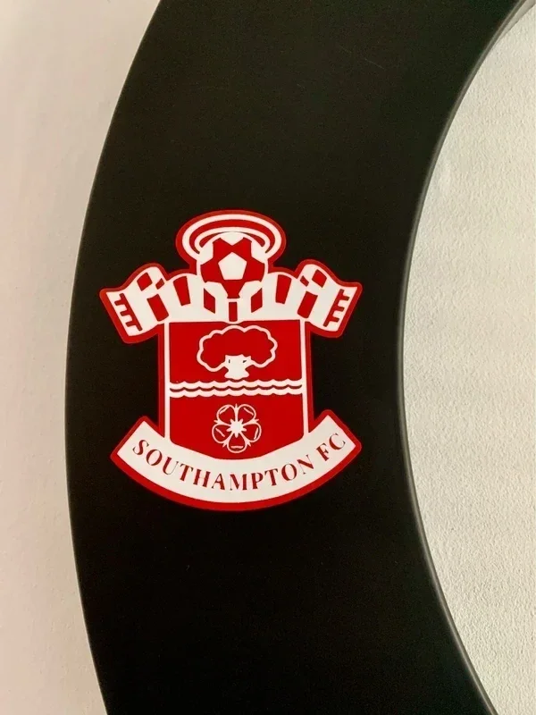 Southampton FC crest sticker on a curved black surface.