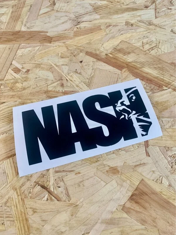 A black NASA logo sticker on a piece of white paper placed on a wooden surface.
