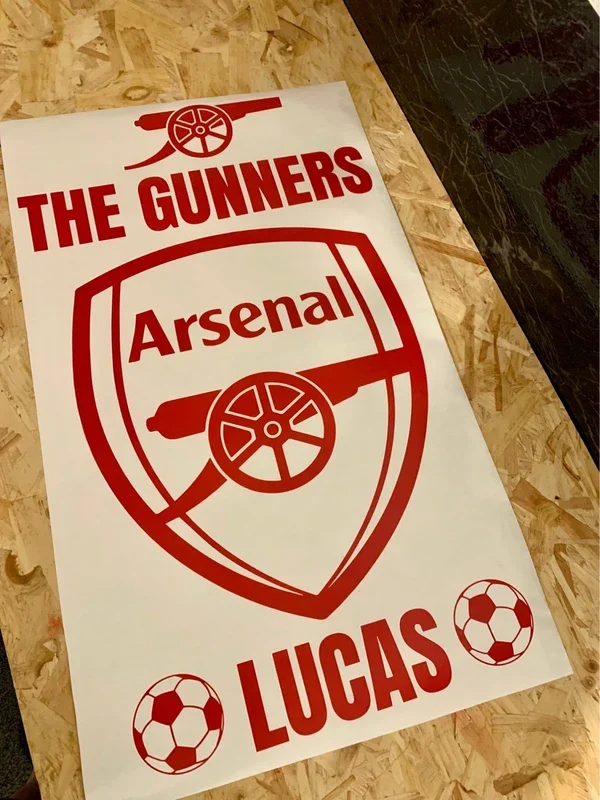 Sign with Arsenal football logo, a cannon, and the words 'The Gunners,' 'Arsenal,' 'Lucas,' and two soccer ball icons.