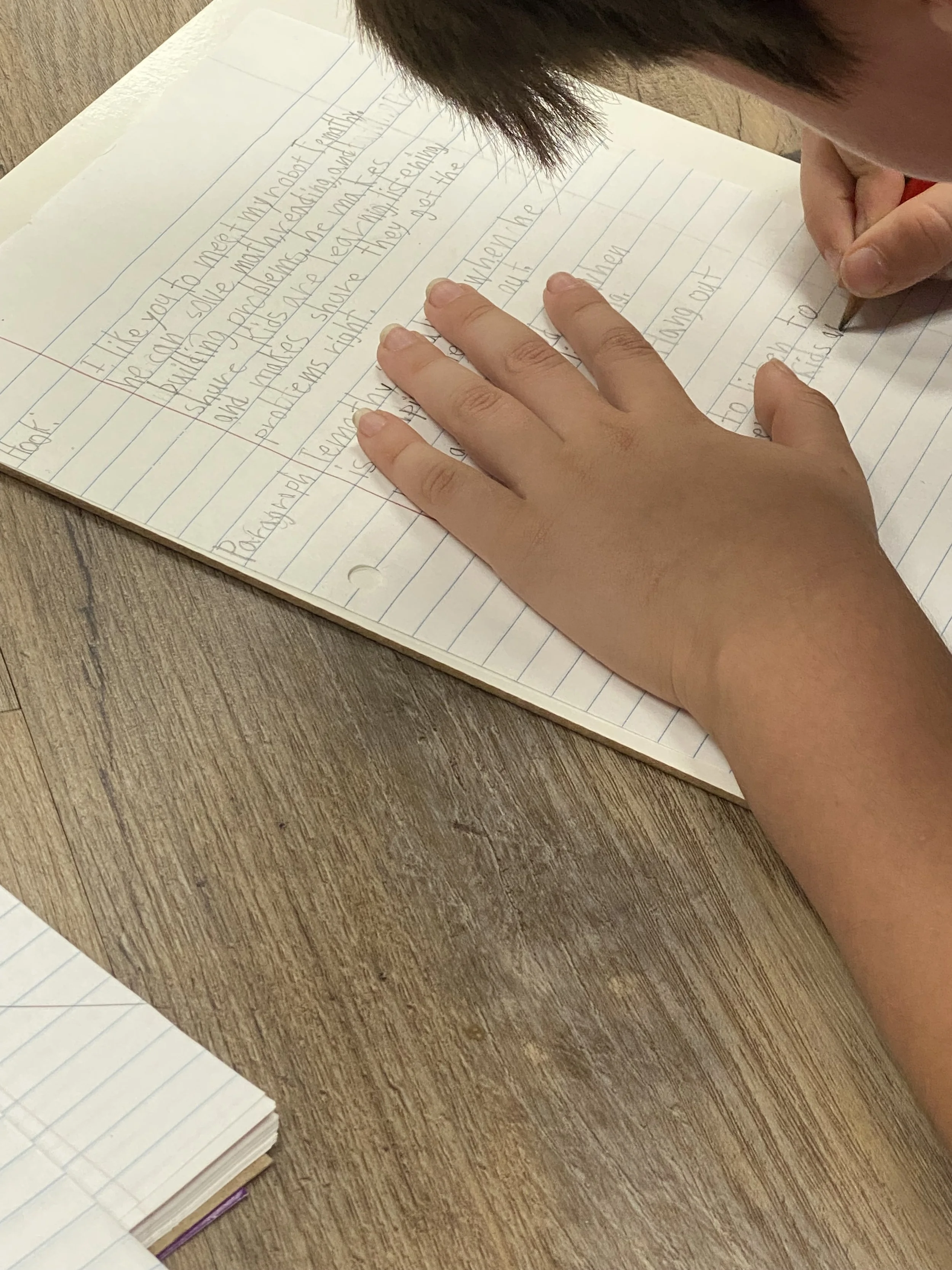 Student working on writing during tutoring at House of Emet in Tyler, TX