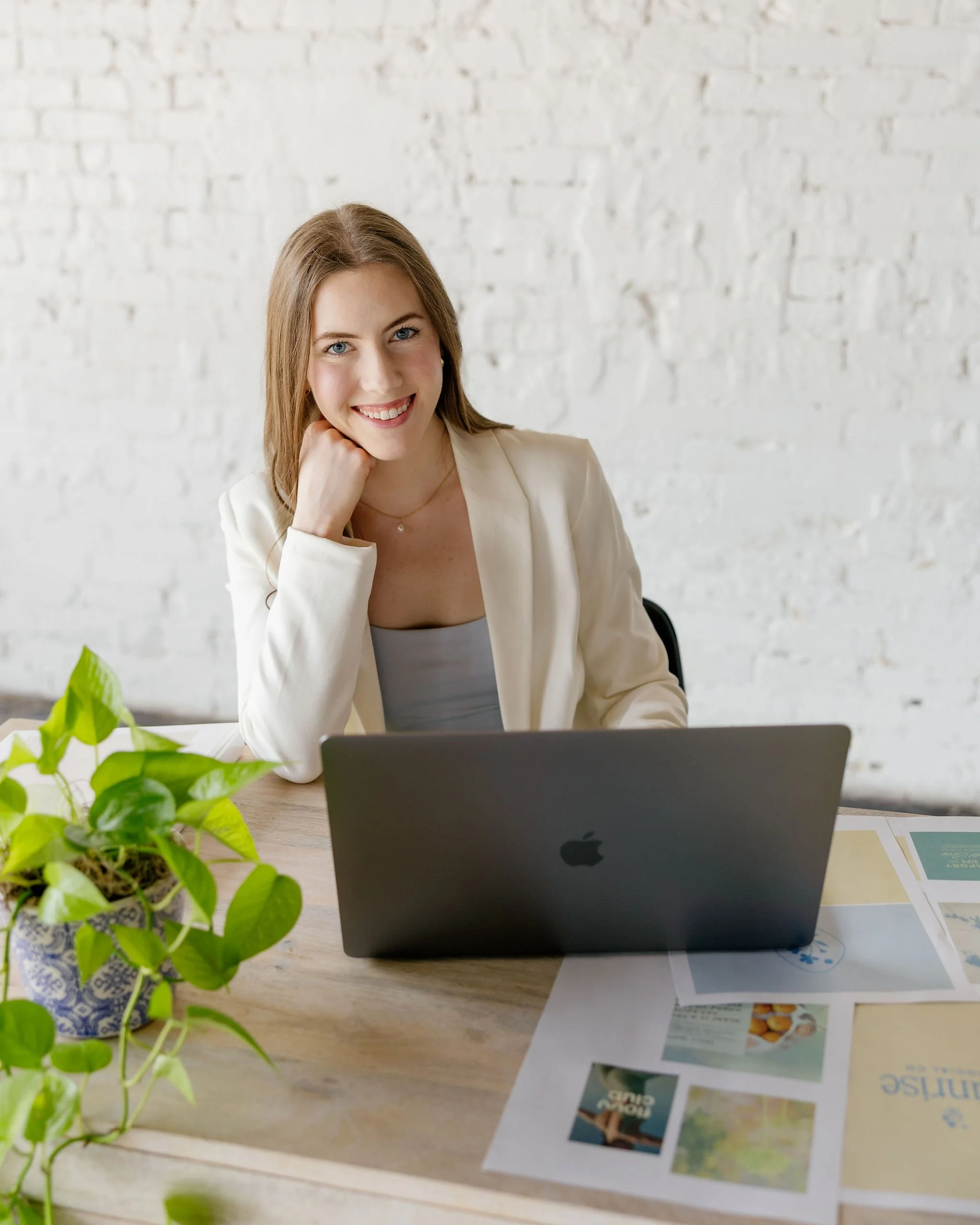Rachael Mayorga of Sunrise Social Co. smiling and sitting at a desk with a laptop.