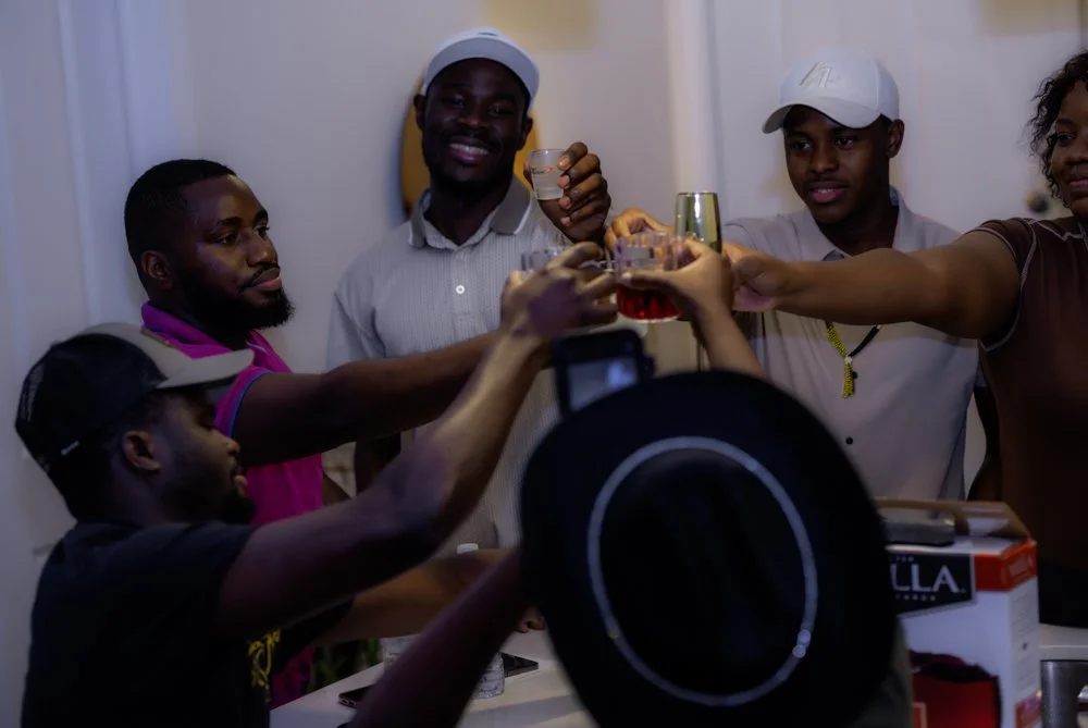 A group of people celebrating and holding drinks in a toast.