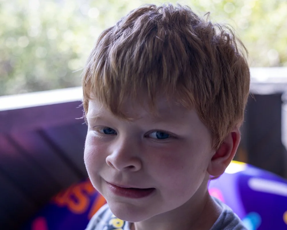 A young boy with red hair and blue eyes having an uncertain or confused expression.