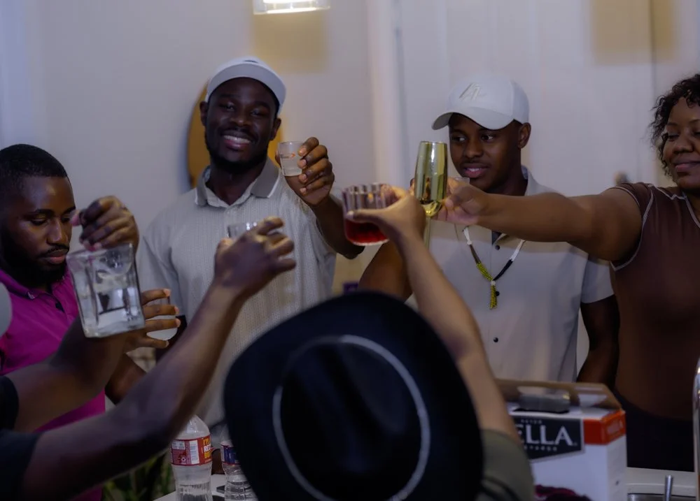 Group of diverse friends celebrating with drinks at a party, raising glasses in a toast.