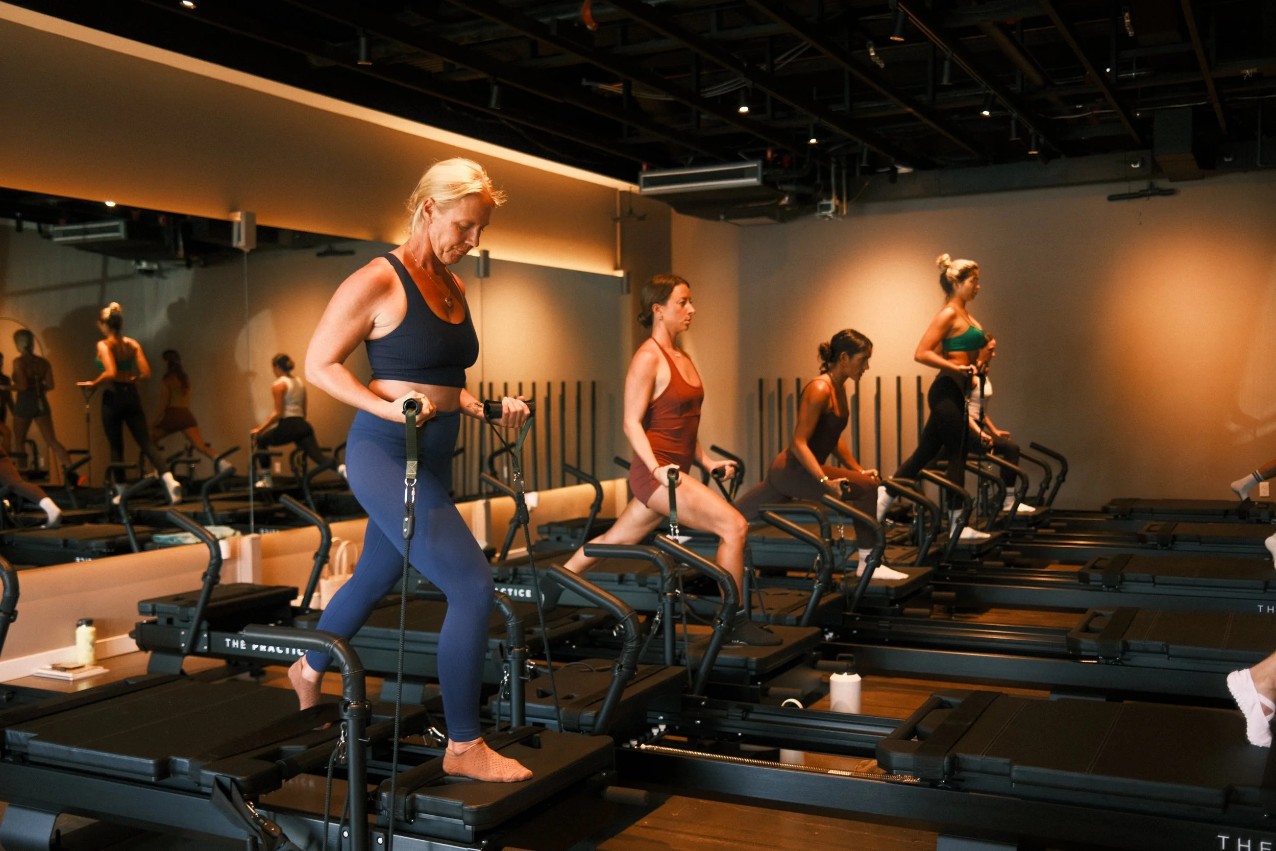 Group class performing lower-body SRT movements on the XFormer.