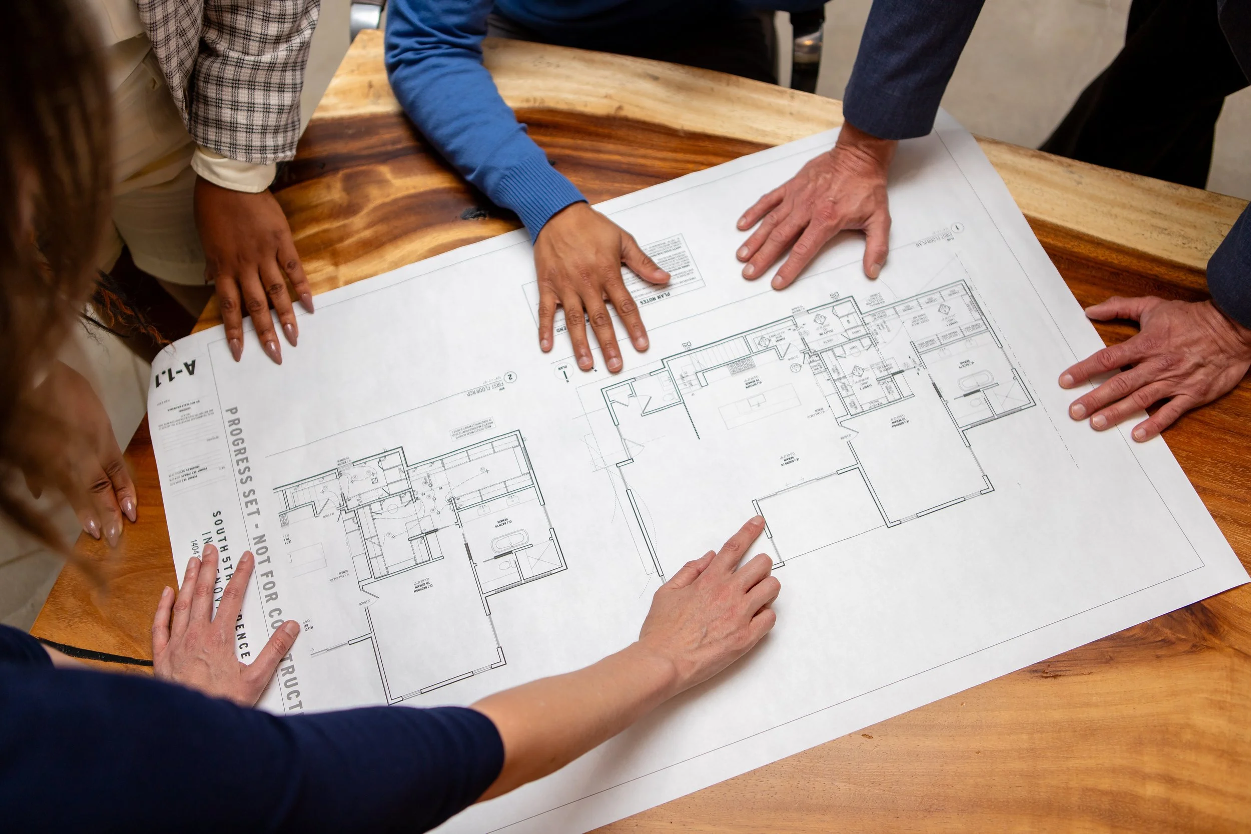 Business development team reviewing architectural plans to expand into the Austin TX market
