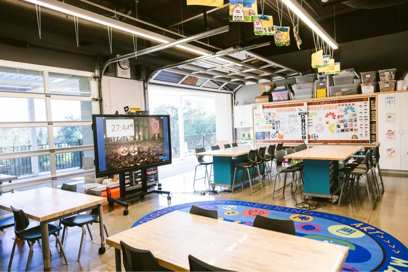 California International School STEM lab with workbench tables and a rolling display screen